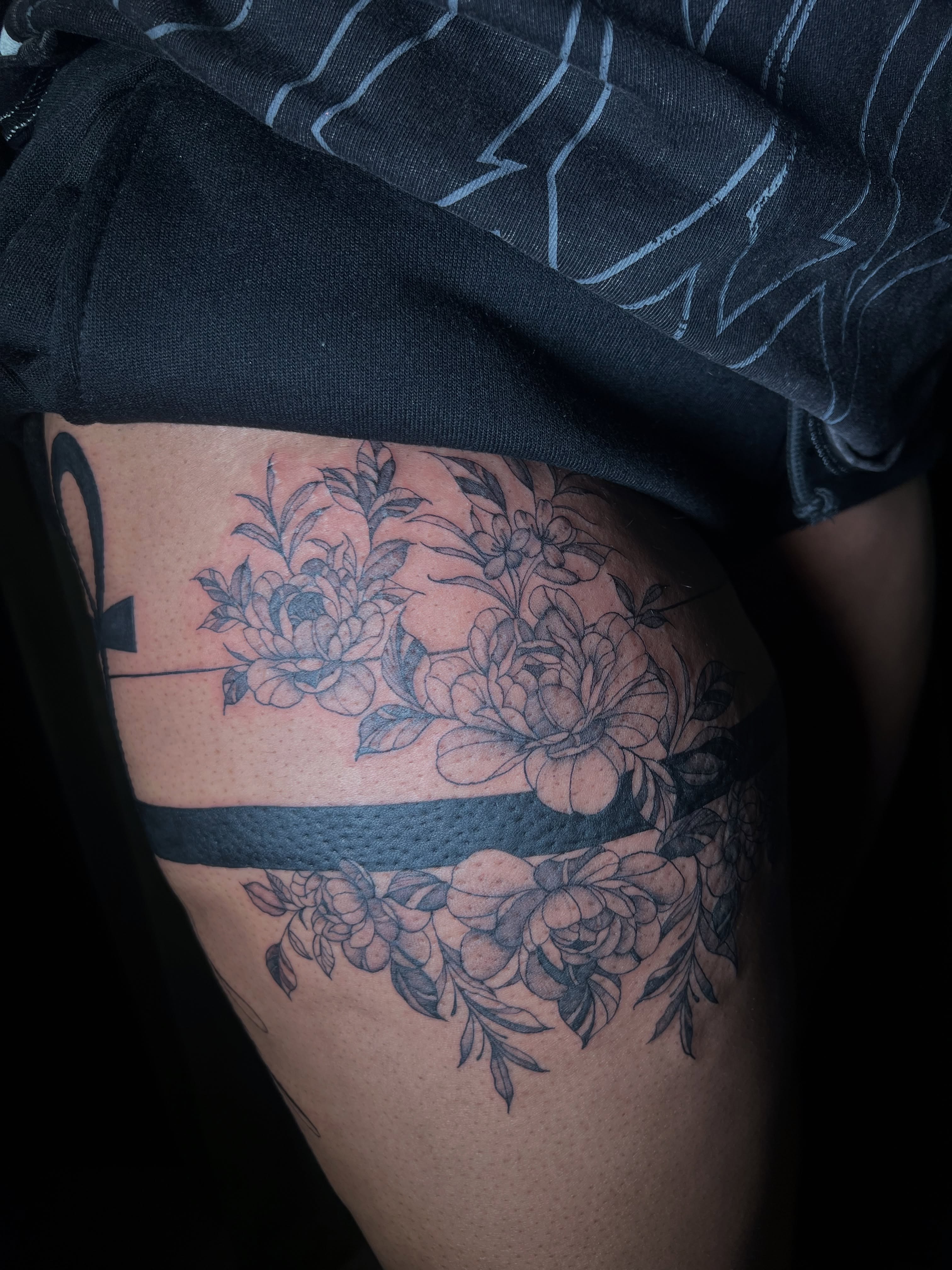 Floral arrangement black and grey tattoo on the thigh by V
