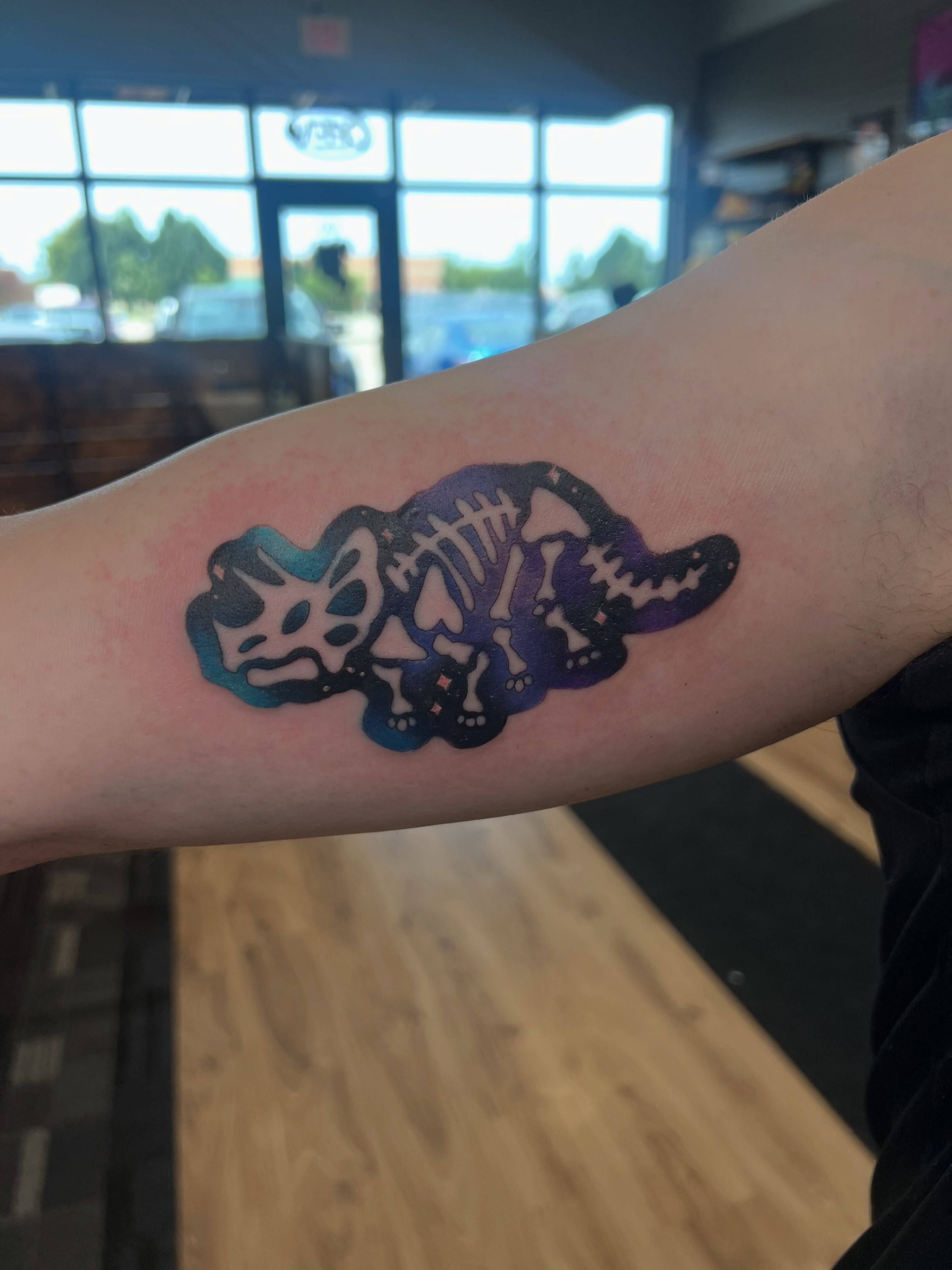 Dinosaur skeleton geometric tattoo on the forearm by Bailey Goodwin, Ankeny, Iowa