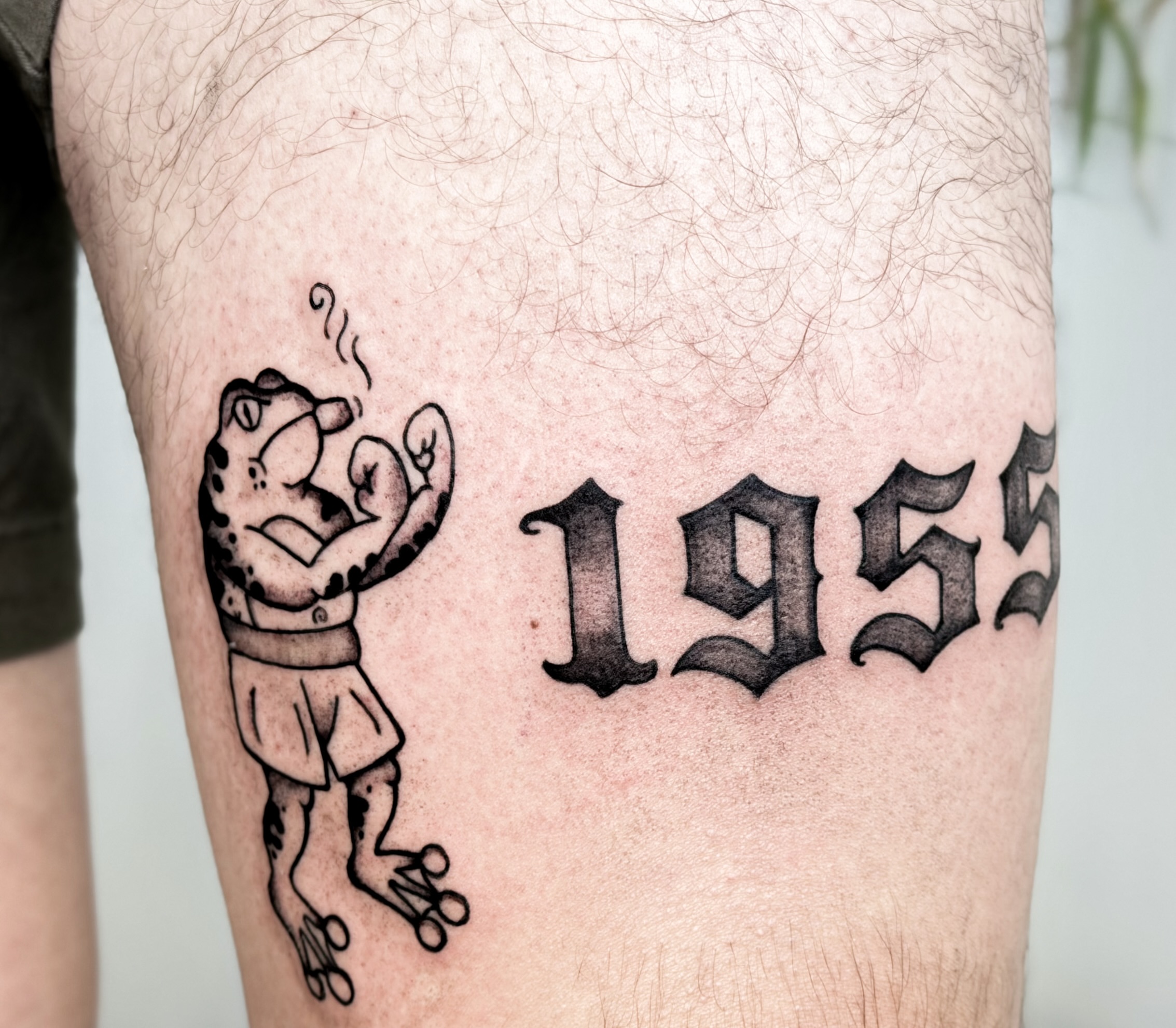Frog smoking pipe black and grey tattoo on the thigh by Tatuajes Denver