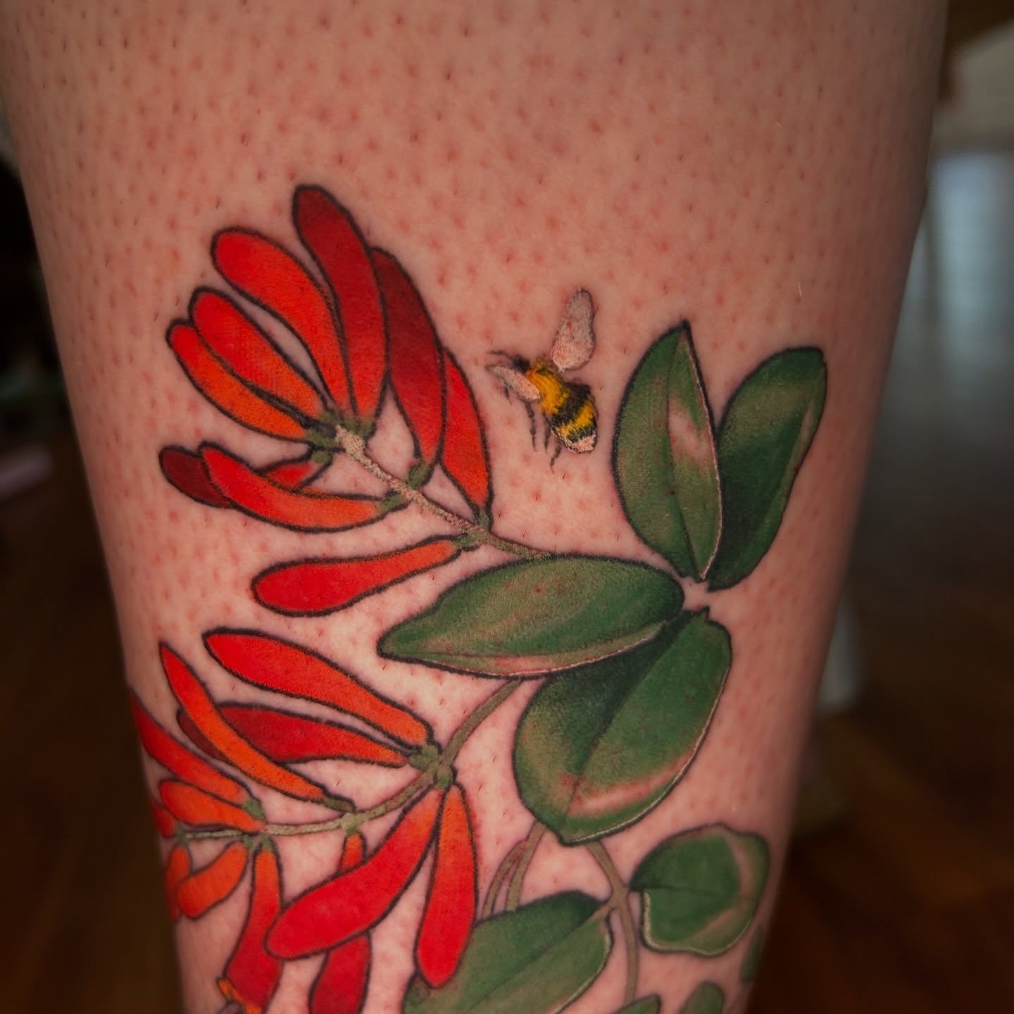 Flower and bee realism tattoo on the forearm by Anna Sylvan Tattoos