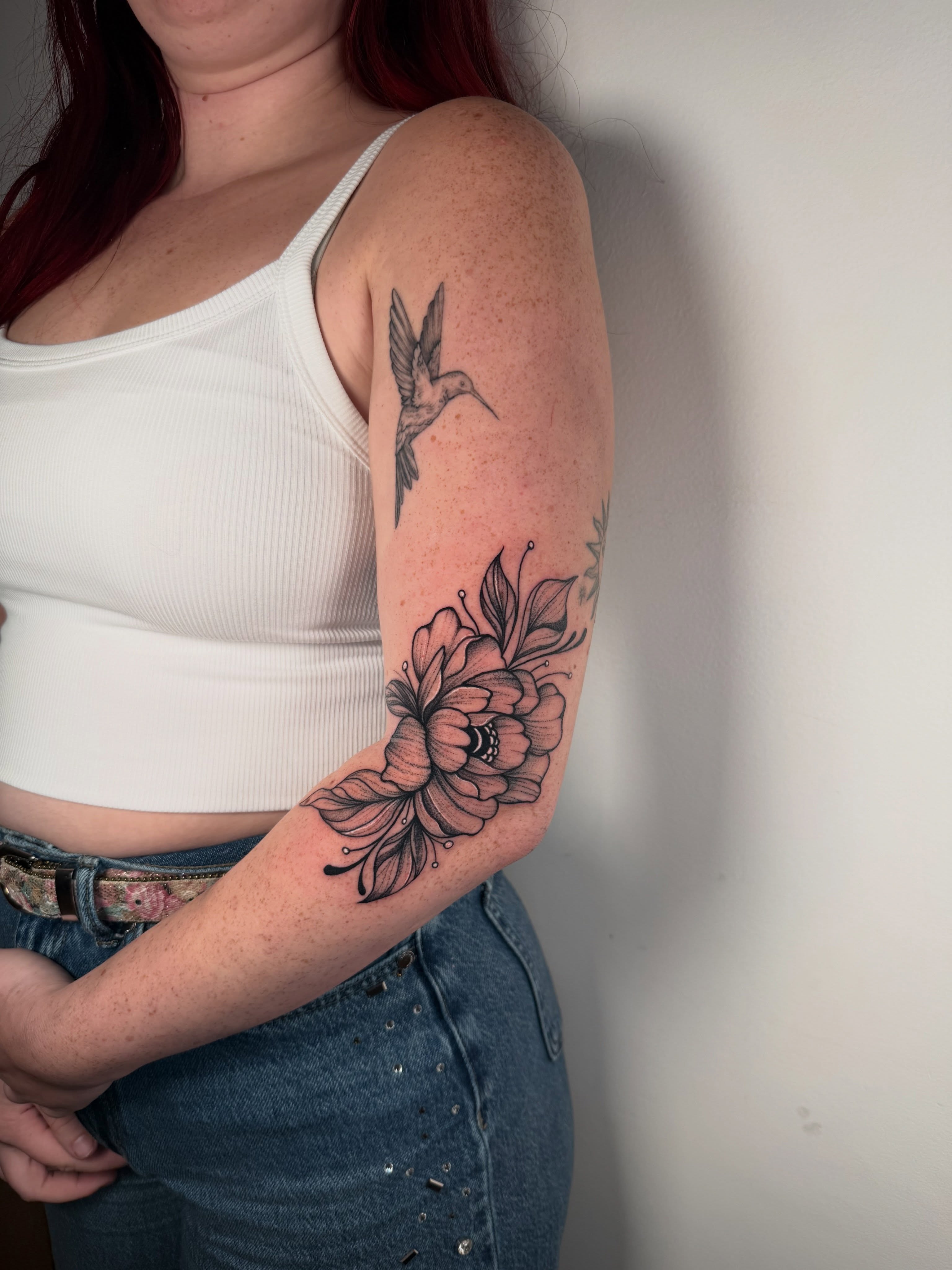 Flower and hummingbird black and grey tattoo on the forearm by Elisa