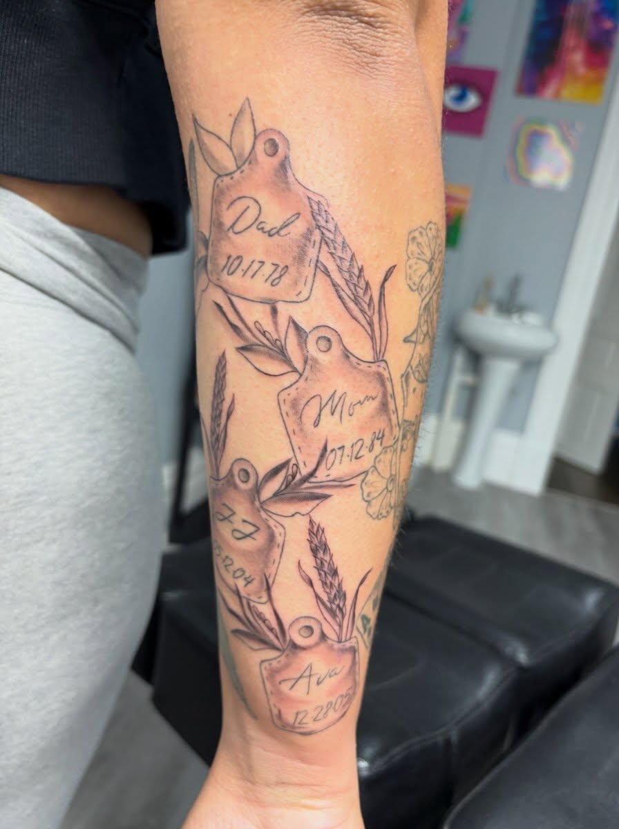 Family tags black and grey tattoo on the forearm by Andrea 🎨🖌