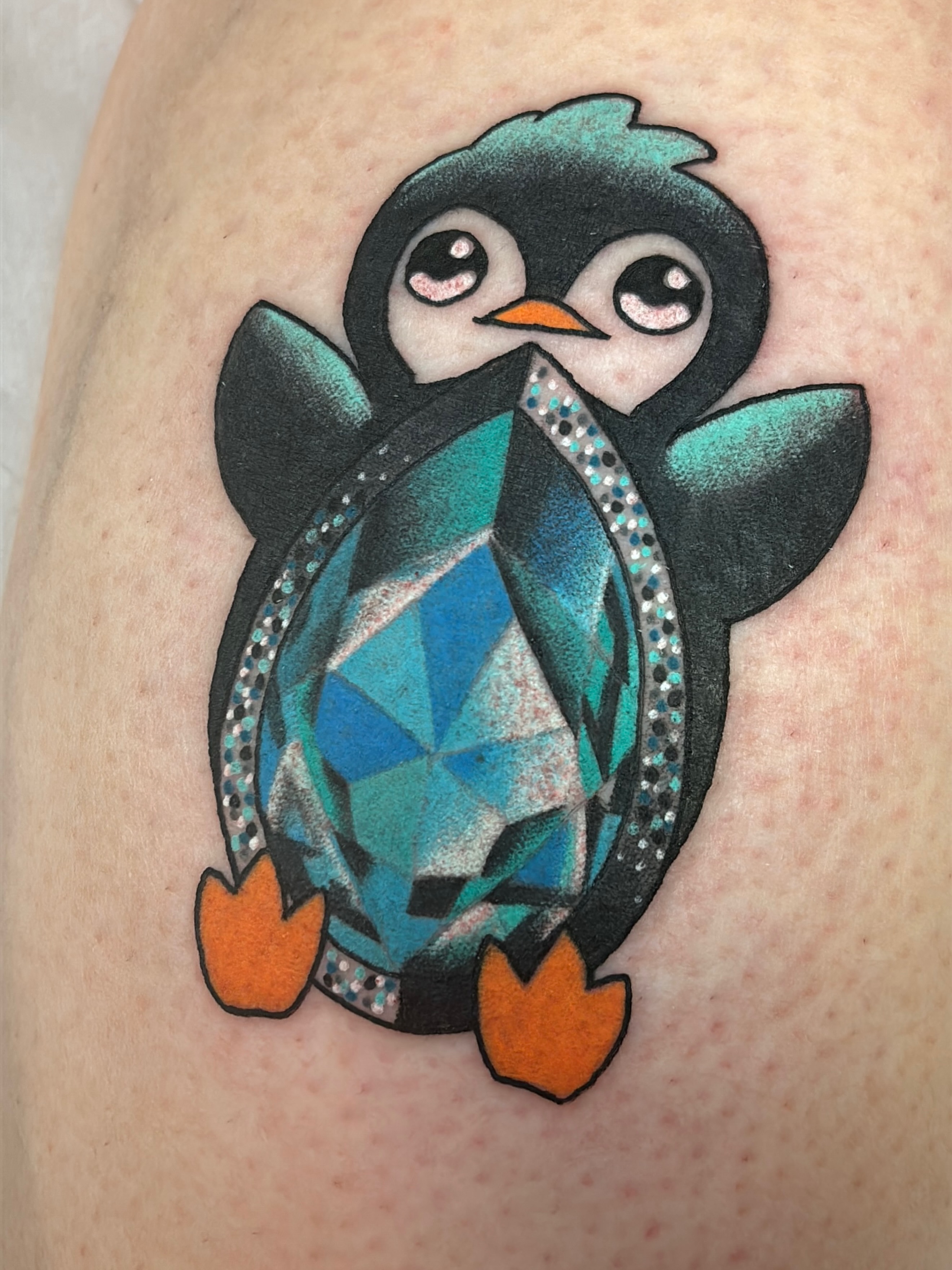 Penguin geometric tattoo on the thigh by Latesha Burnley