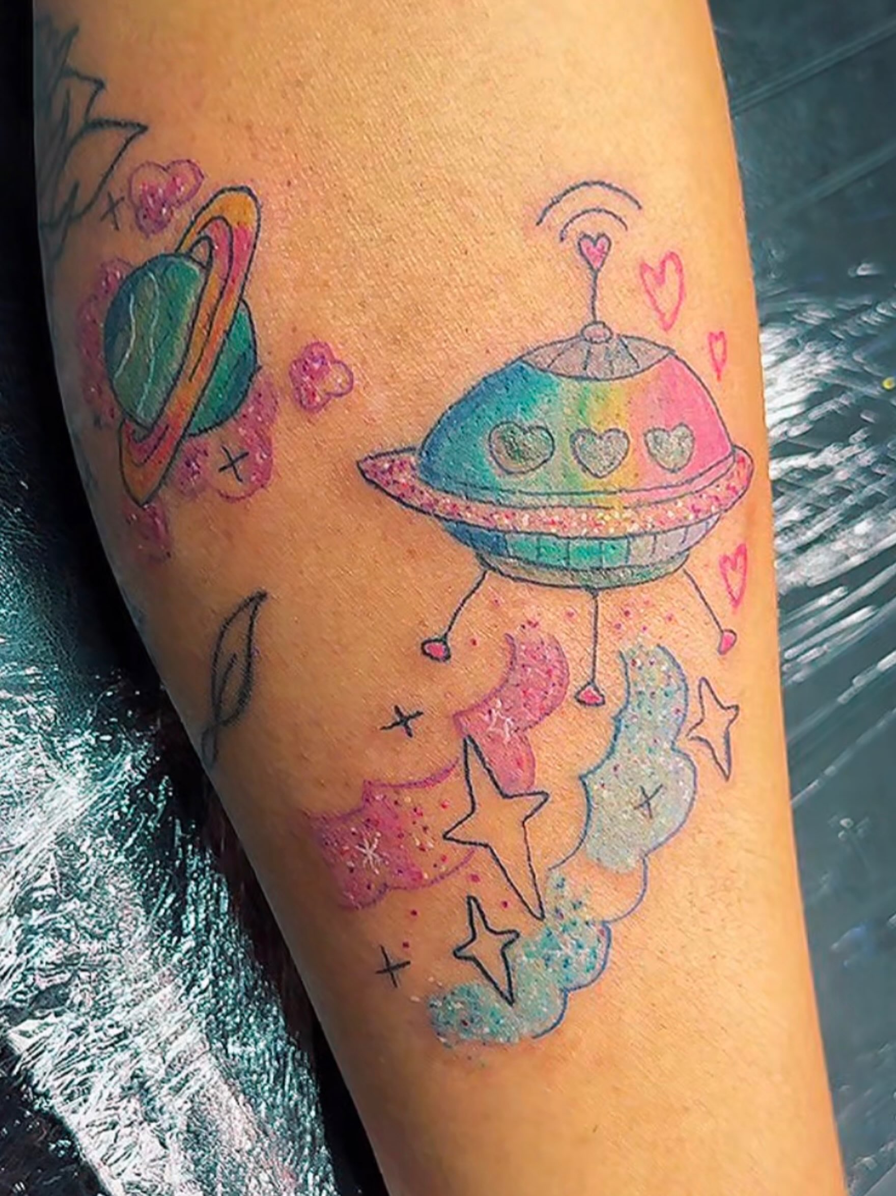 Space-themed UFO new school tattoo on the forearm by Felicia Lee, Des Moines, Iowa