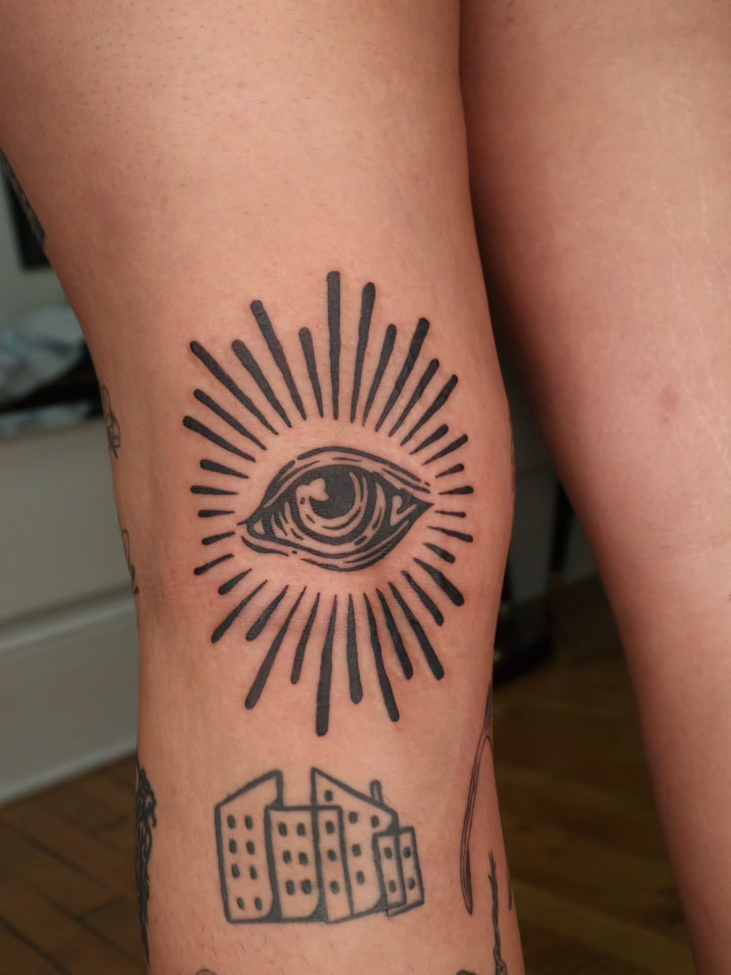 All-seeing eye black and grey tattoo on the thigh by Veronika Lipchak
