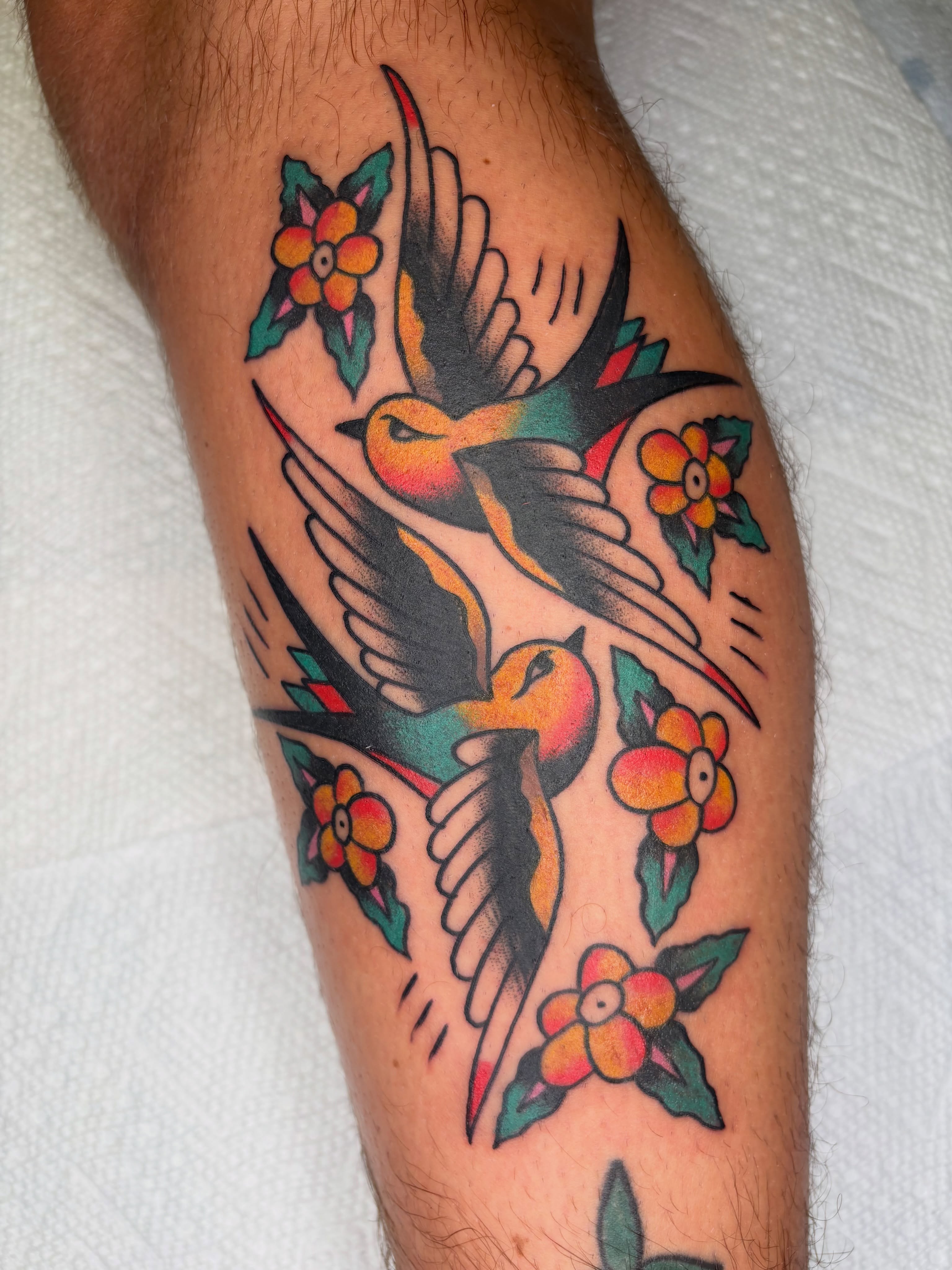Birds and flowers American traditional tattoo on the forearm by Cooper Reichwein