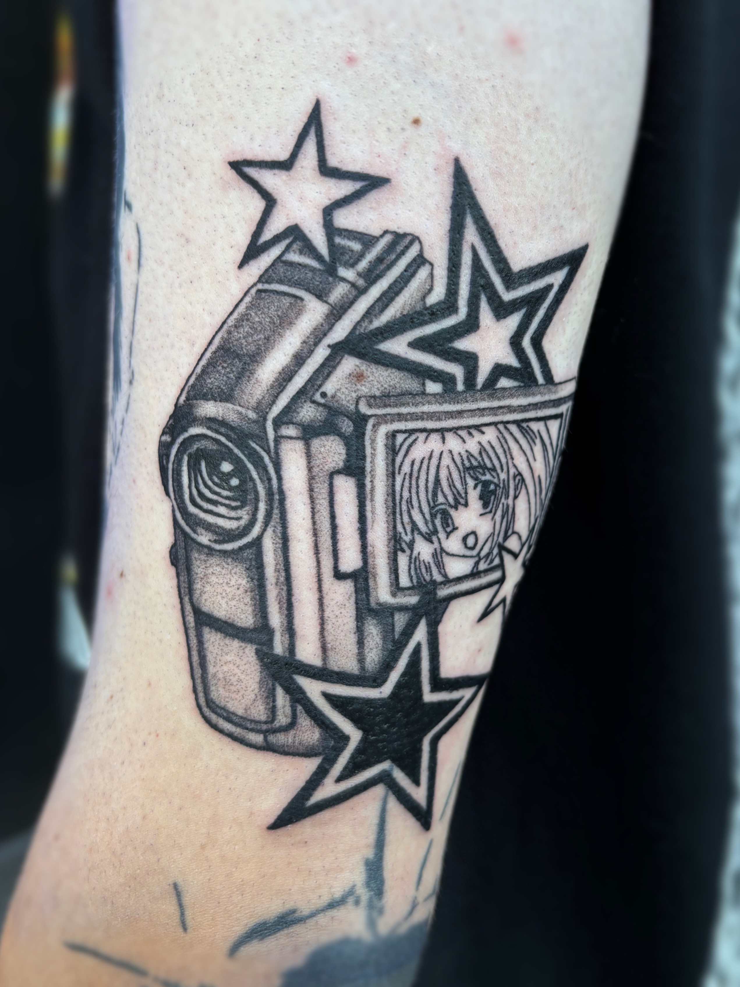 Anime character with camera anime tattoo on the forearm by Cooper, Portland, Oregon