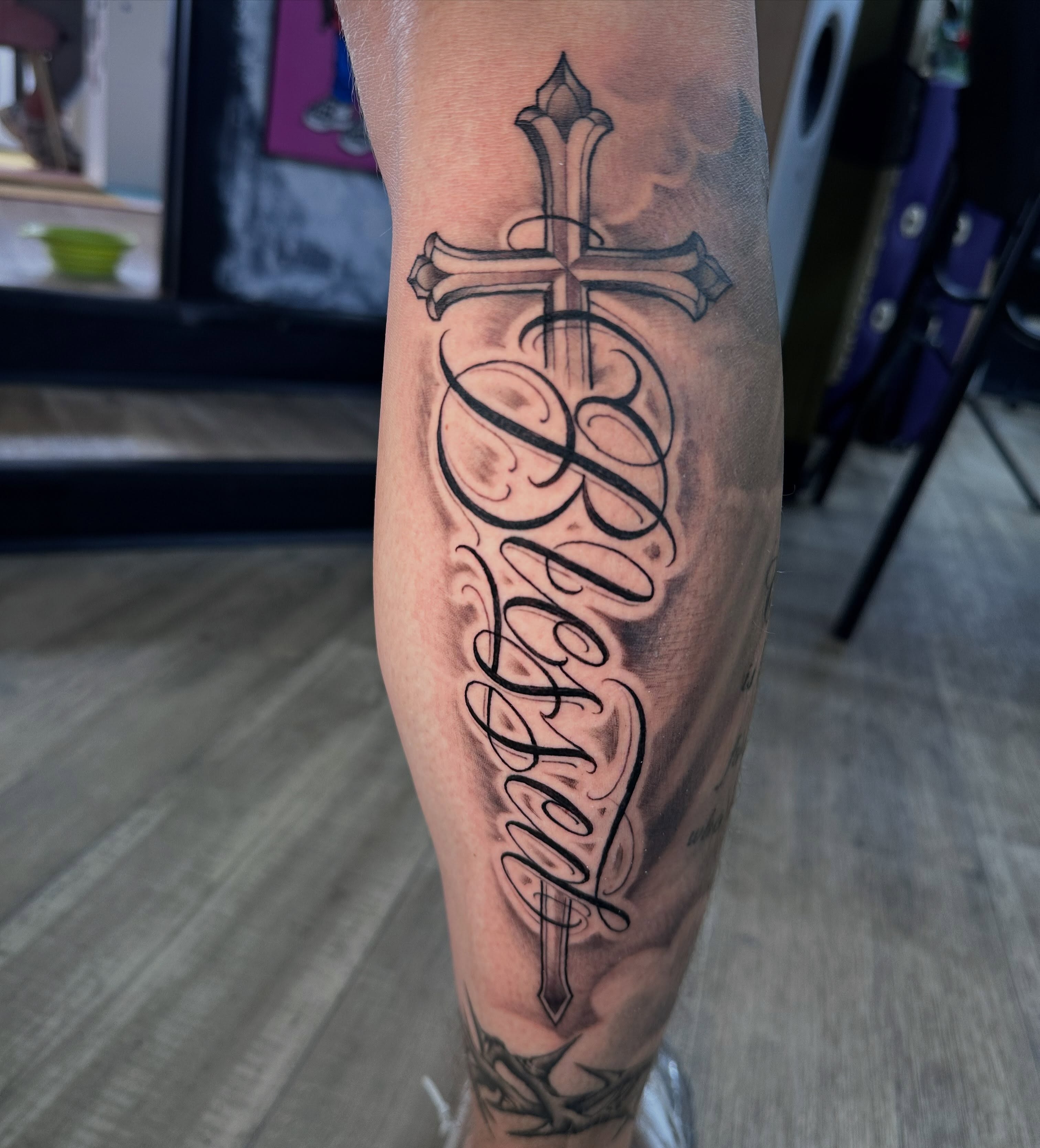 Cross with cursive text black and grey tattoo on the forearm by Dustin Clark, Dayton, Ohio