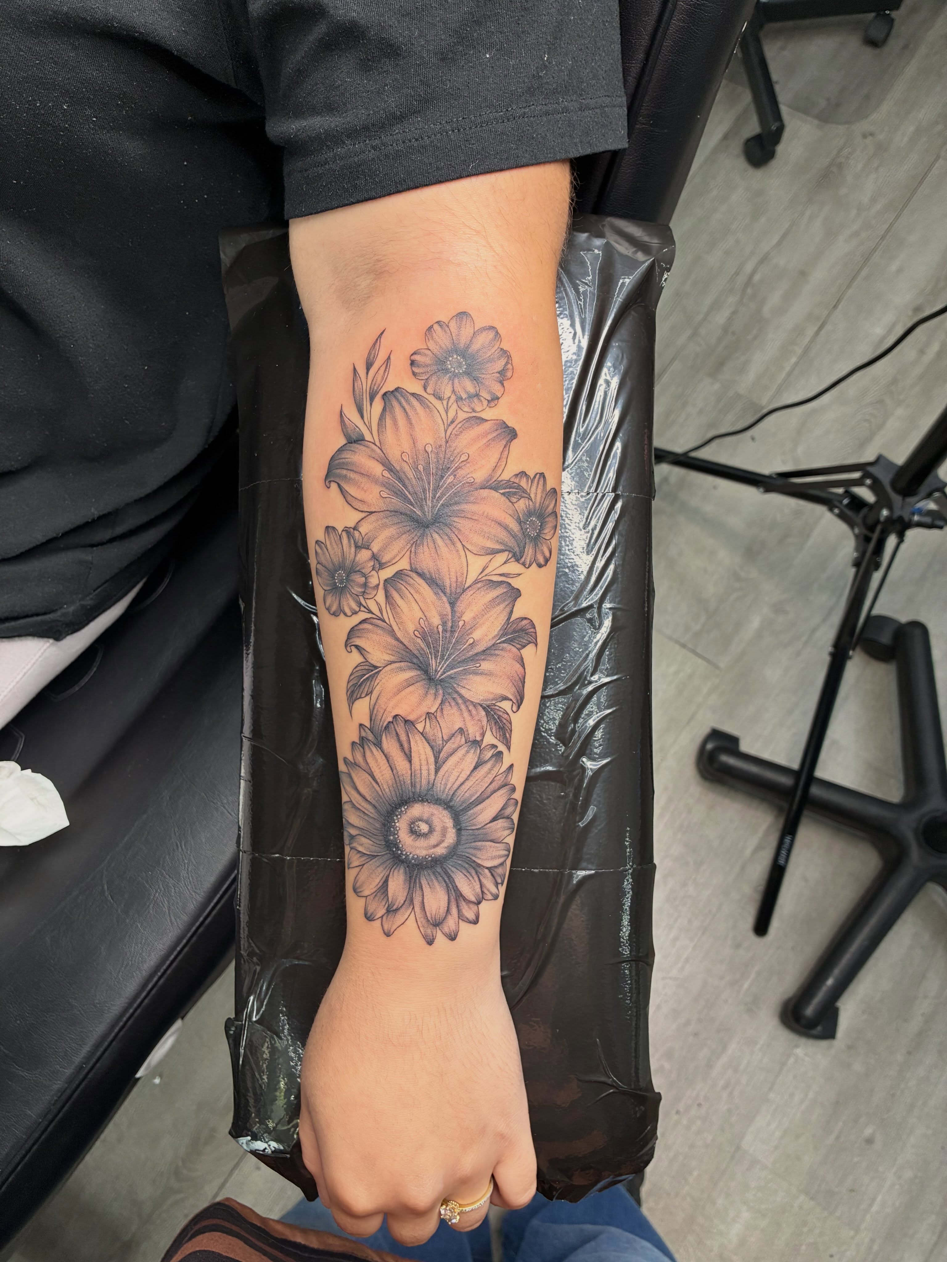Flowers black and grey tattoo on the forearm by Tattoos by Hailey