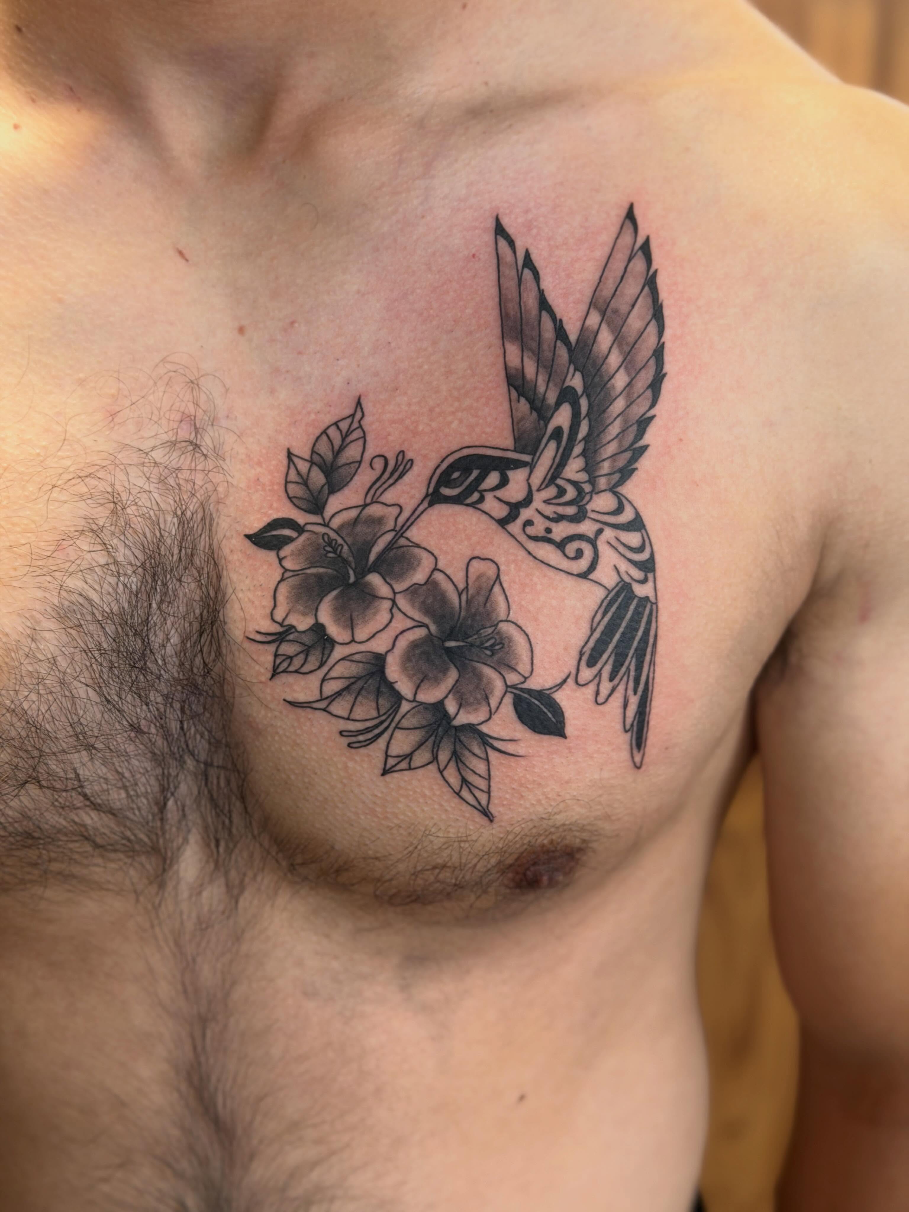 Hummingbird and flowers black and grey tattoo on the chest by Anna sabrowsky