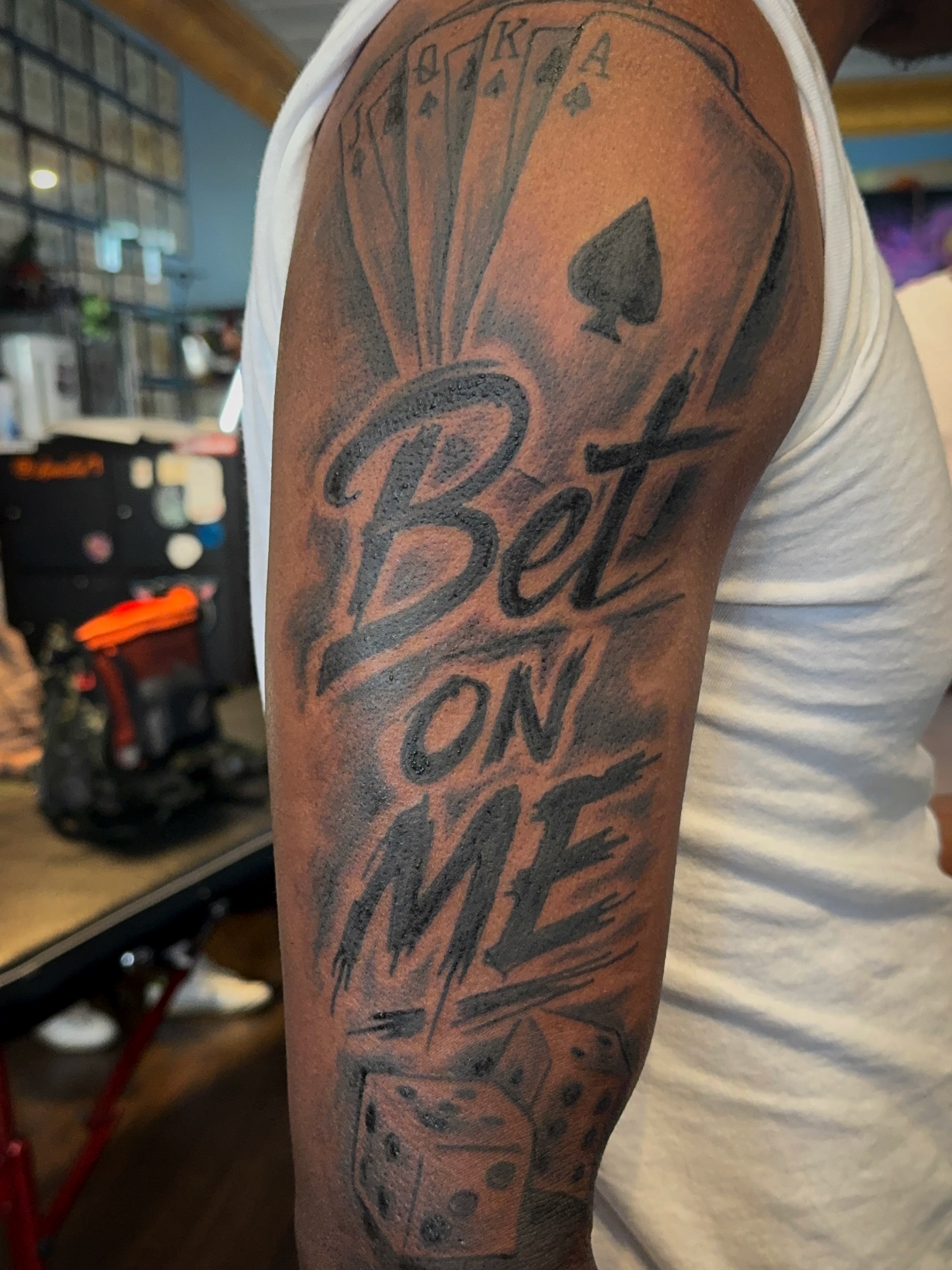 Bet on me black and grey tattoo on the upper arm by Misty Dawn Brothers, Dayton, Ohio