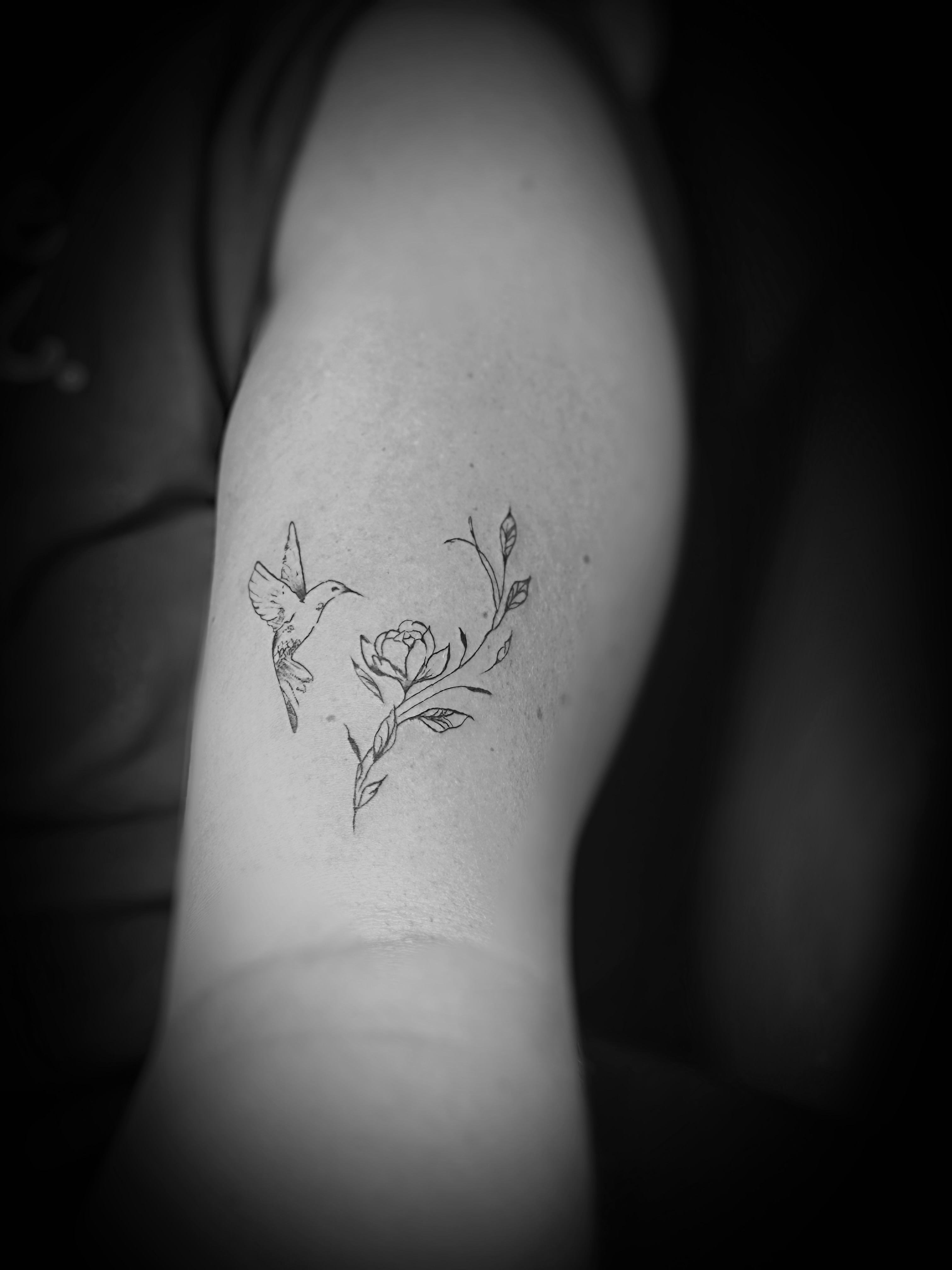 Hummingbird and flower black and grey tattoo on the forearm by Meagan, Charlotte, North Carolina
