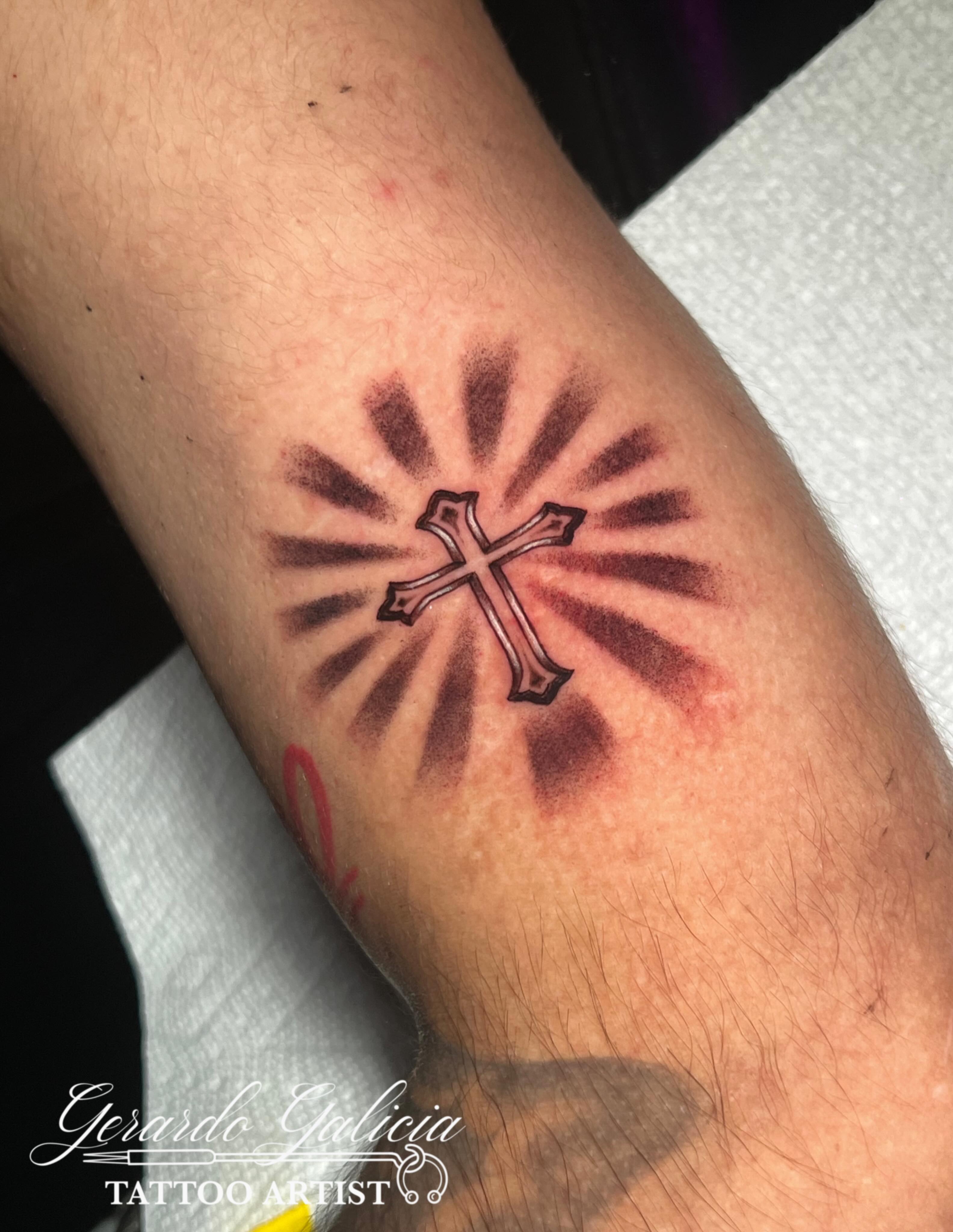 Cross with radiating lines dotwork tattoo on the forearm by Gerardo Galicia, New York, New York
