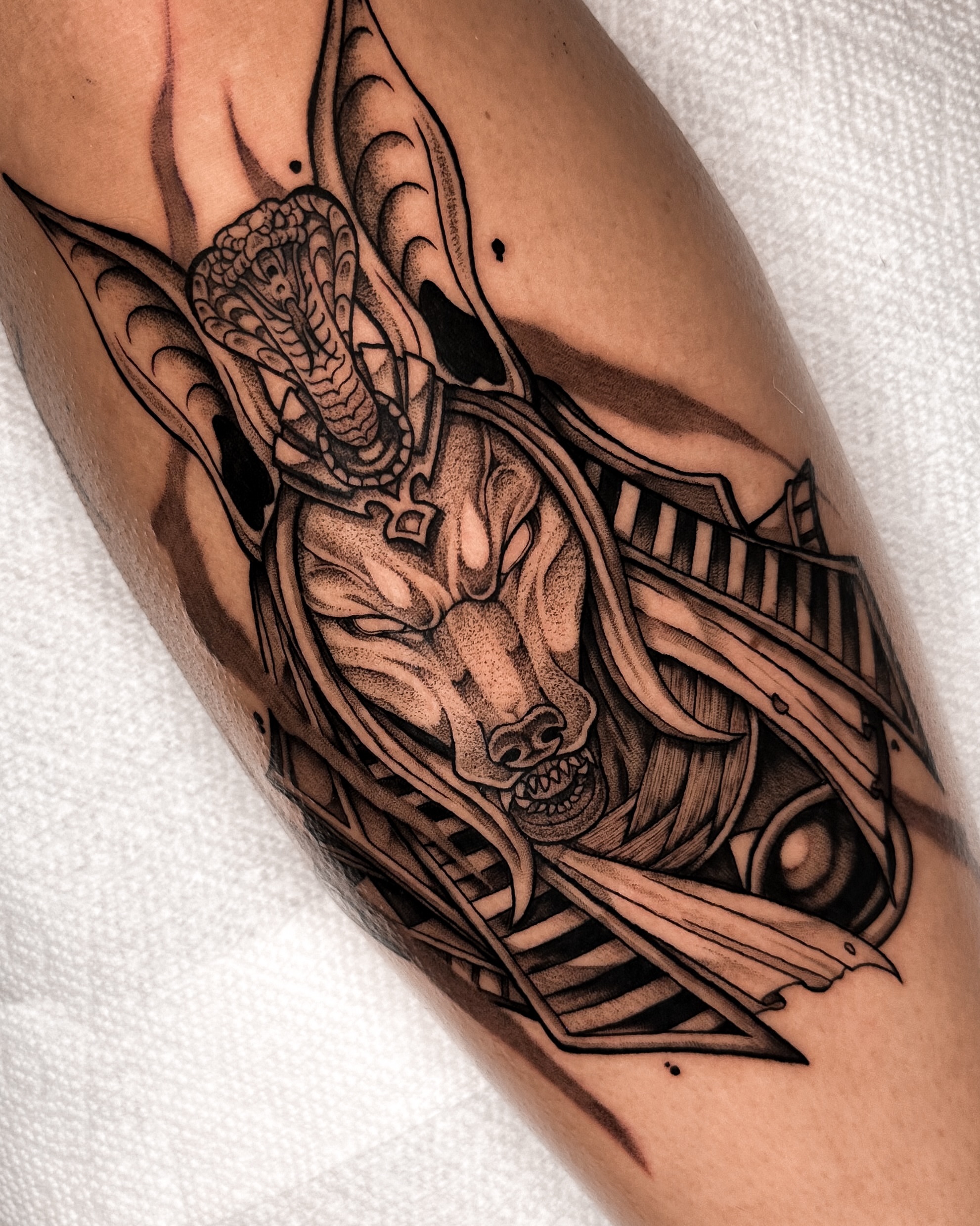 Mask and snake geometric tattoo on the forearm by Taylin Johnson- Illustrative Blackwork, Columbus, Ohio