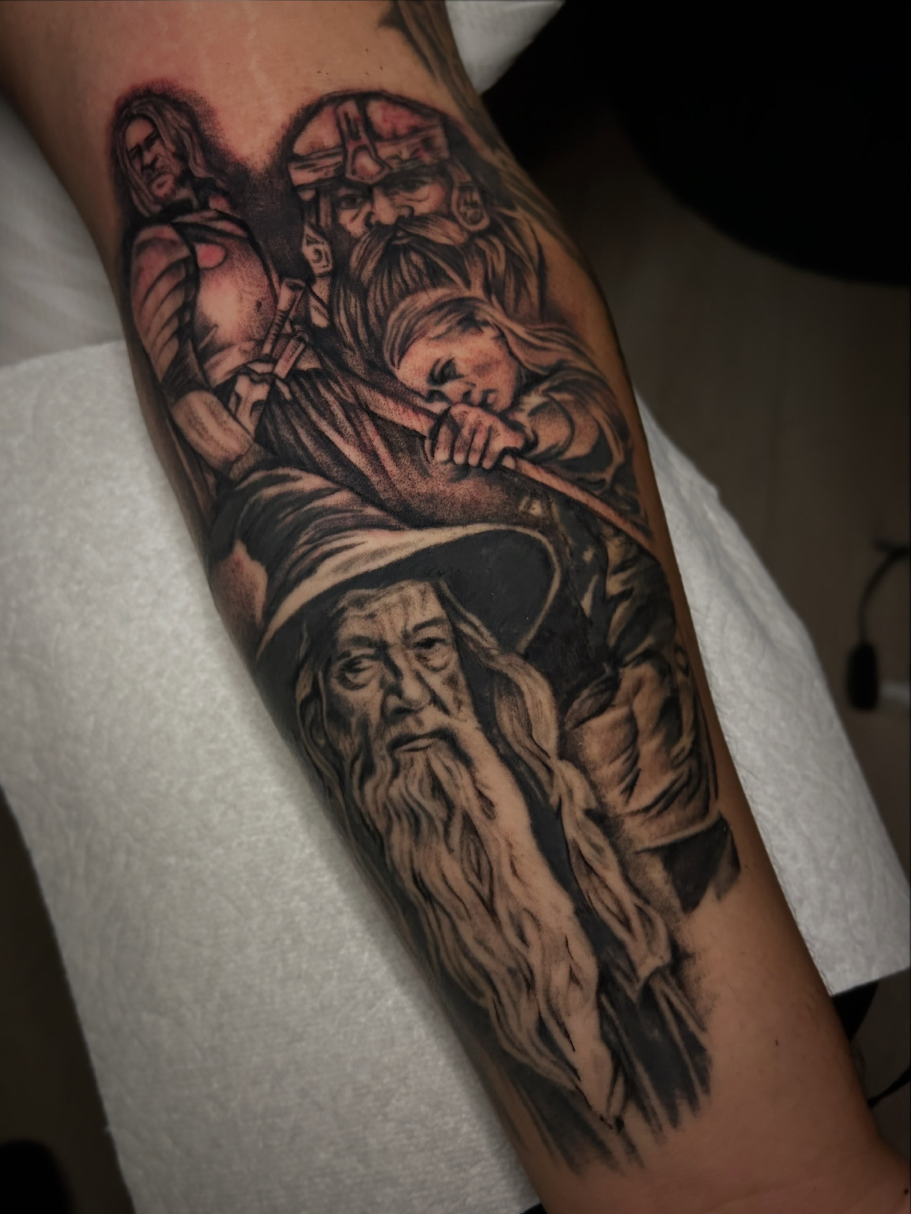 Hobbits and wizard realism tattoo on the forearm by Marky