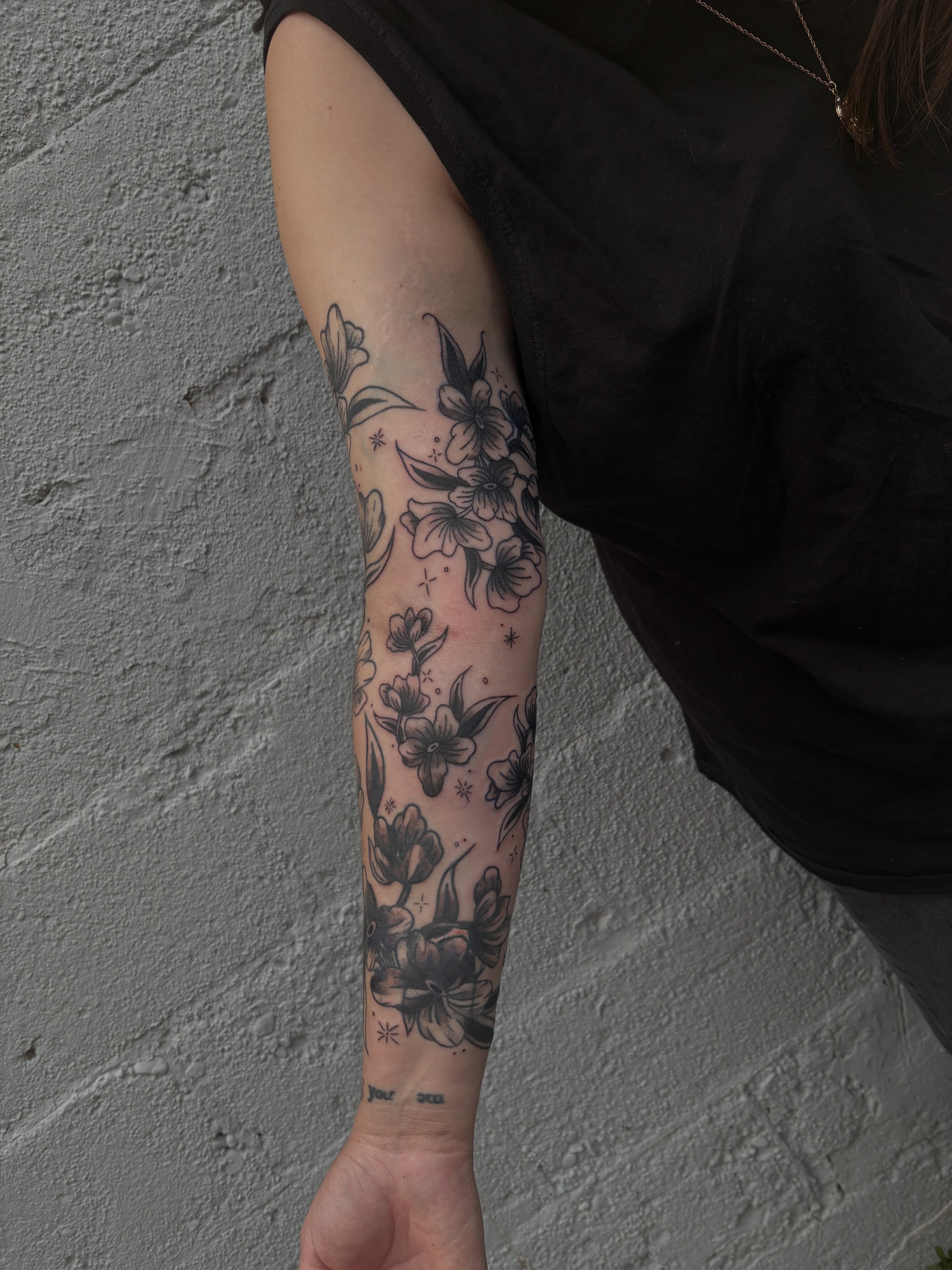 Floral arrangement black and grey tattoo on the forearm by ⋆.˚ ☾ .⭒˚ alaina
