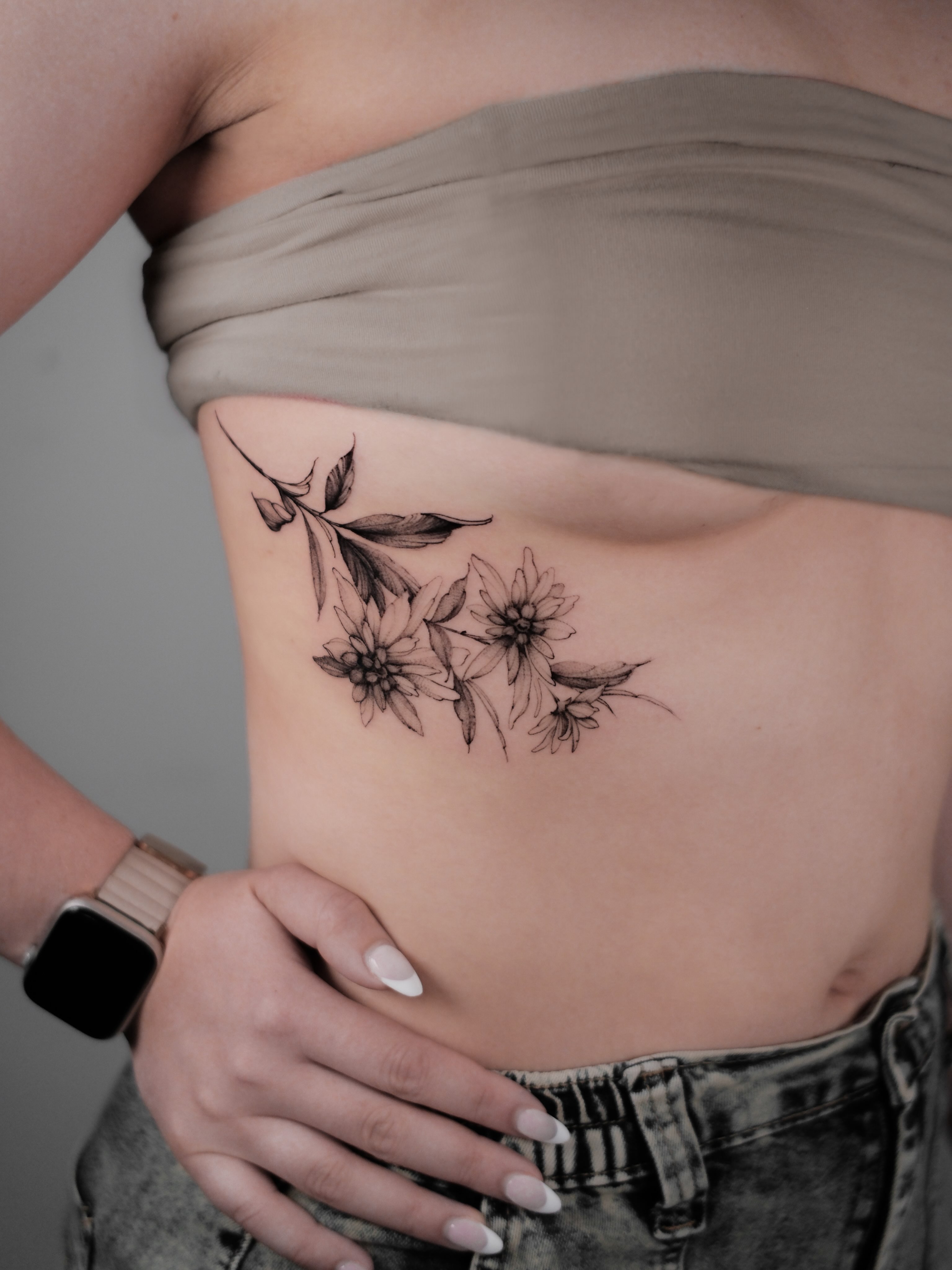Flowers black and grey tattoo on the ribs by Anastasiia