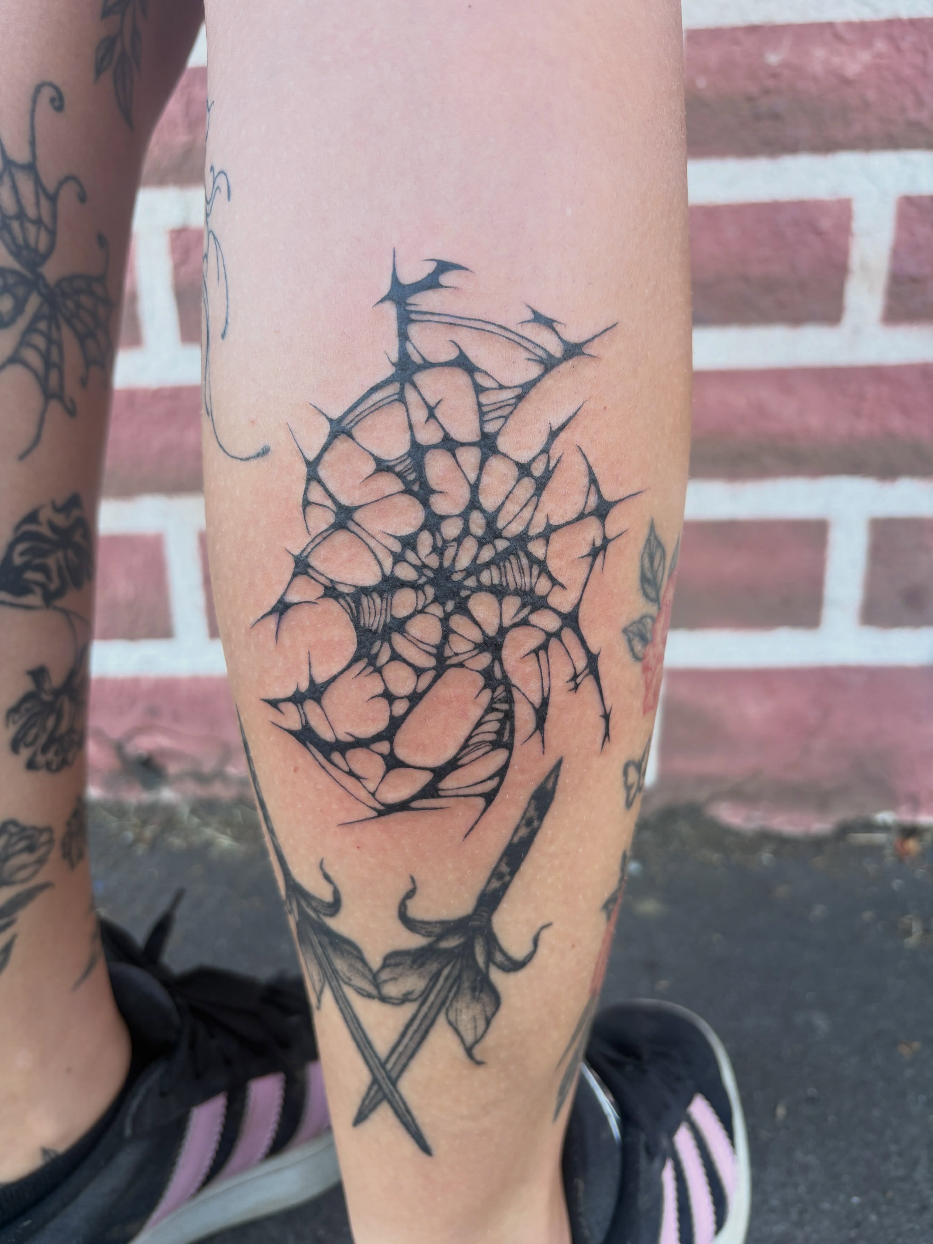 Spiderweb geometric tattoo on the forearm by izzy solae