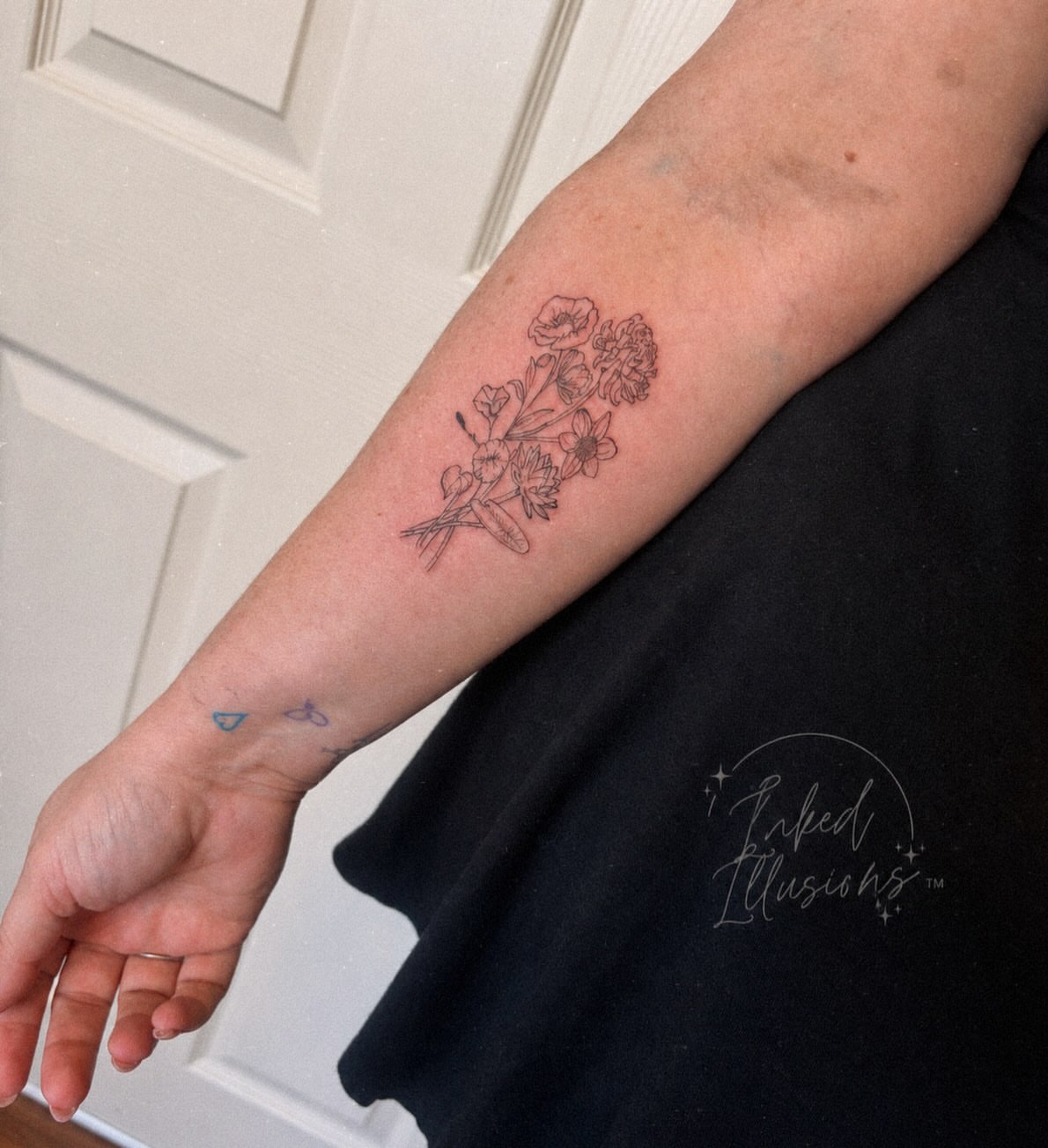 Flower bouquet black and grey tattoo on the forearm by Victoria Cooper
