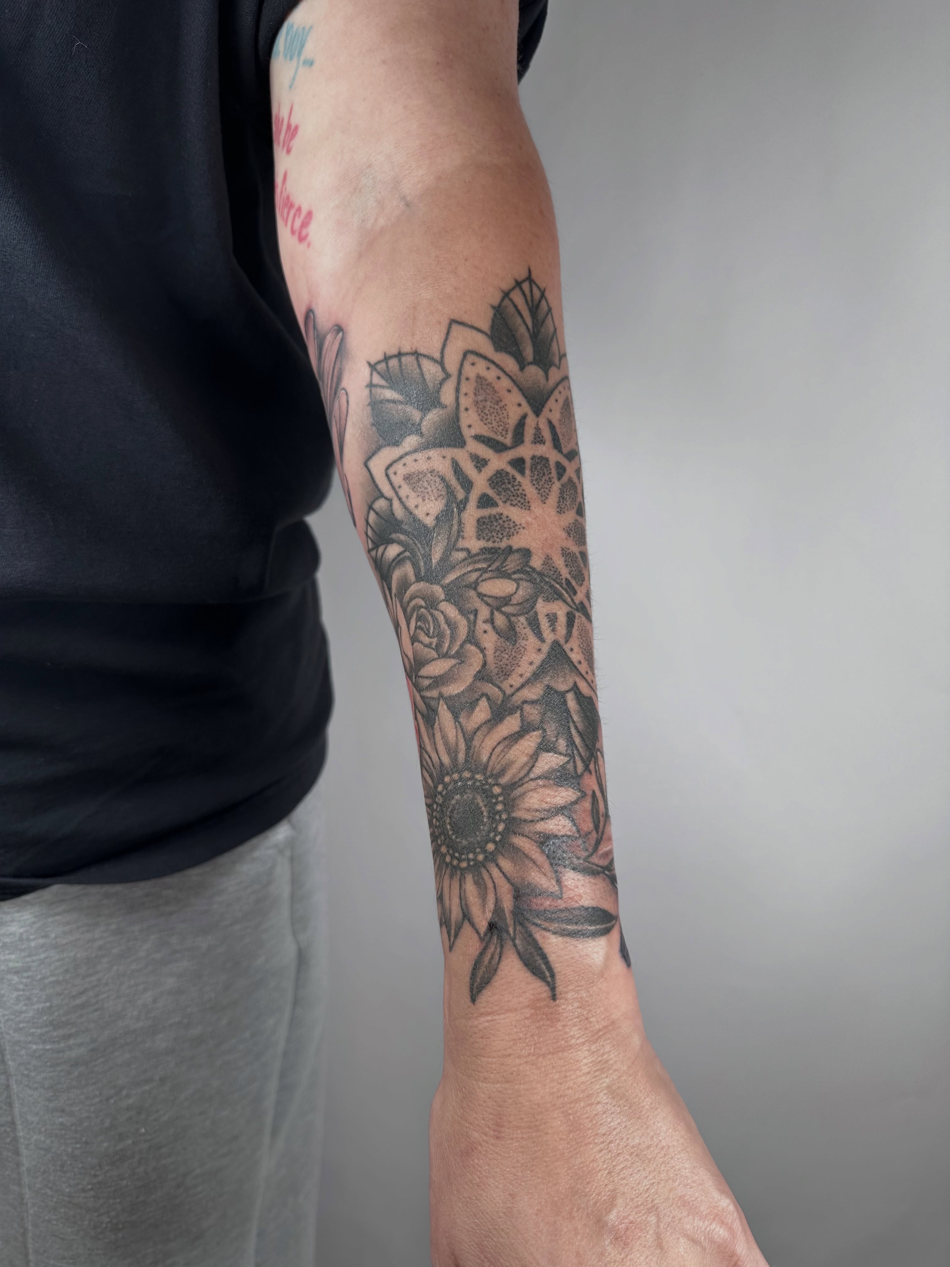 Sunflower and floral bouquet dotwork tattoo on the forearm by Heather Cherish