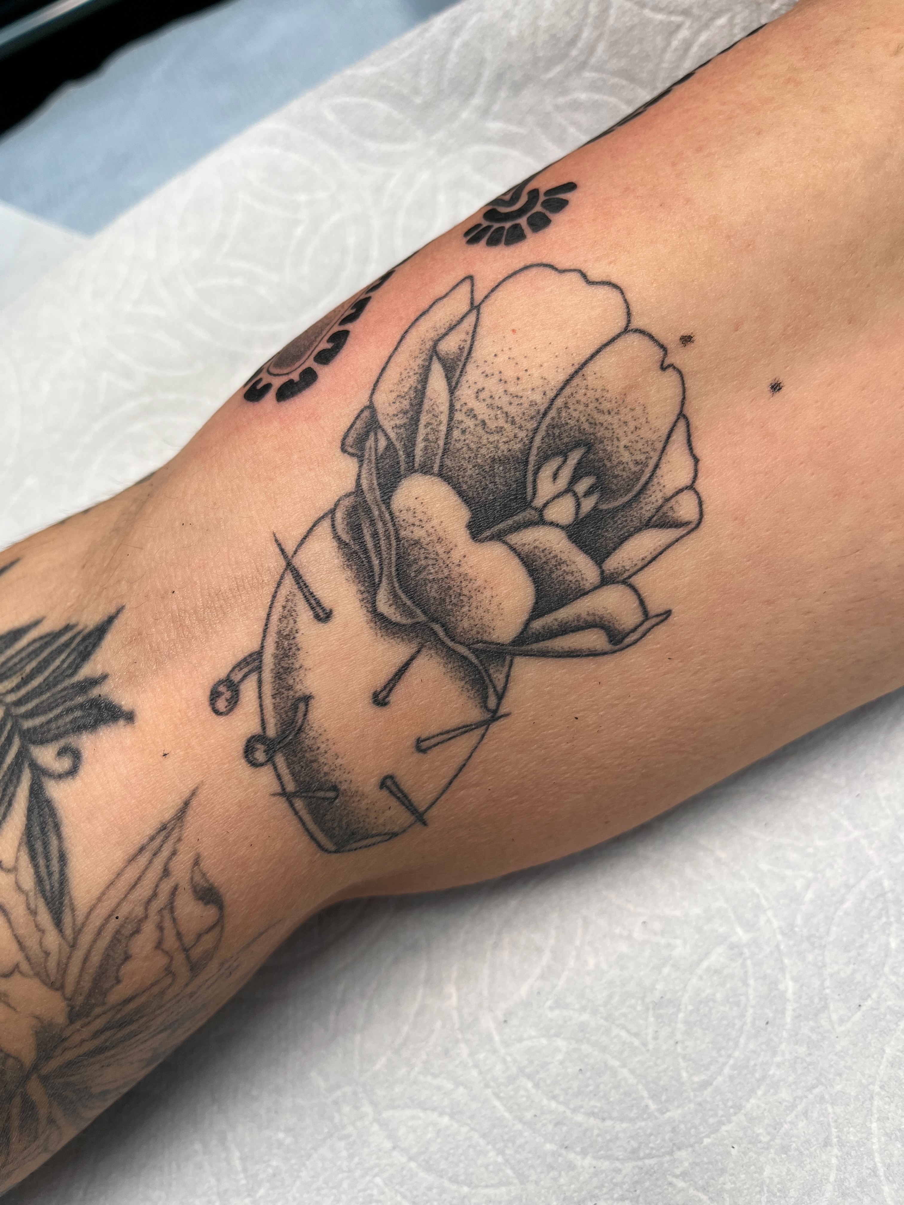 Clock and flower dotwork tattoo on the forearm by christina diaz