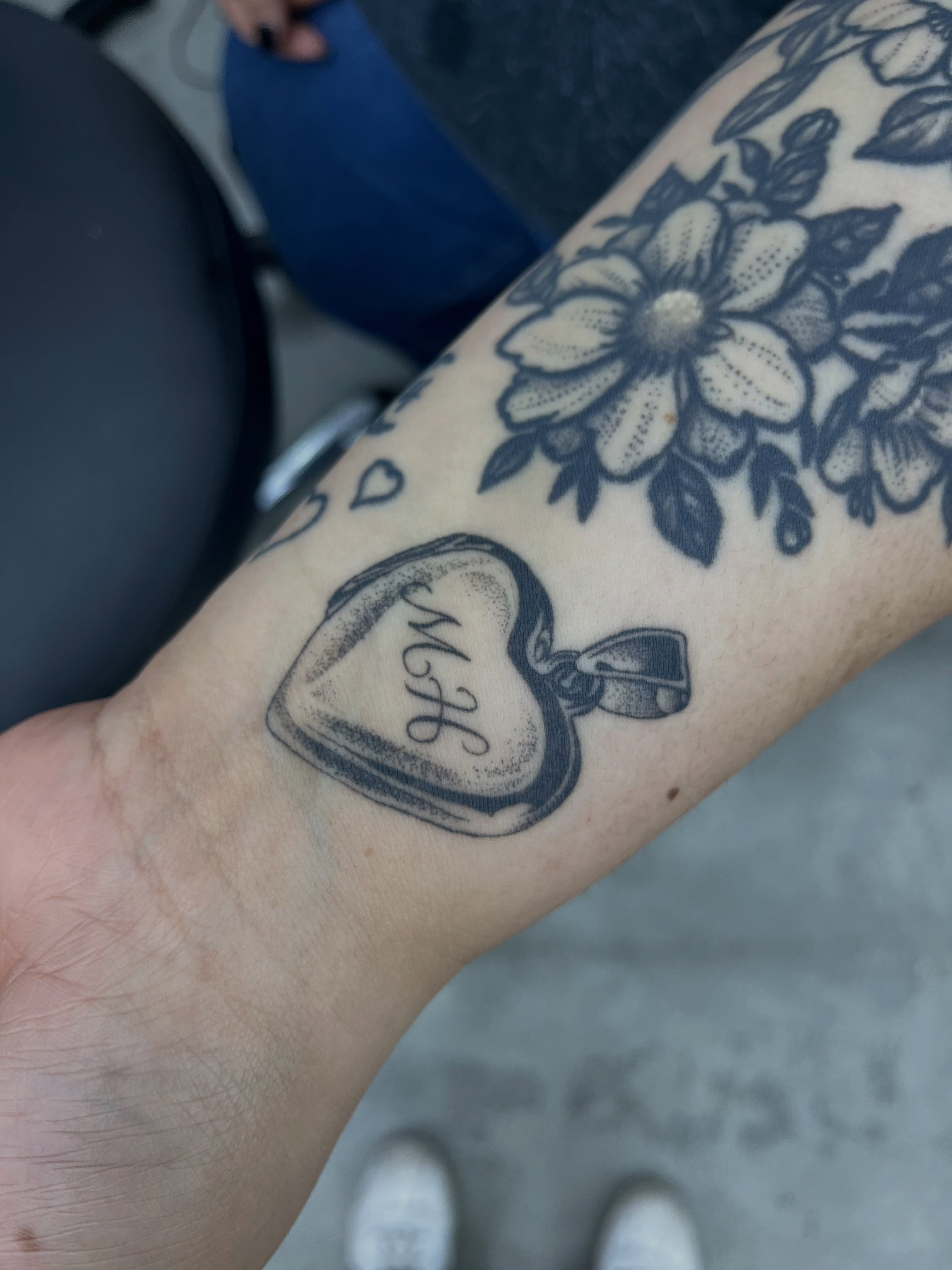 Heart locket black and grey tattoo on the forearm by christina diaz