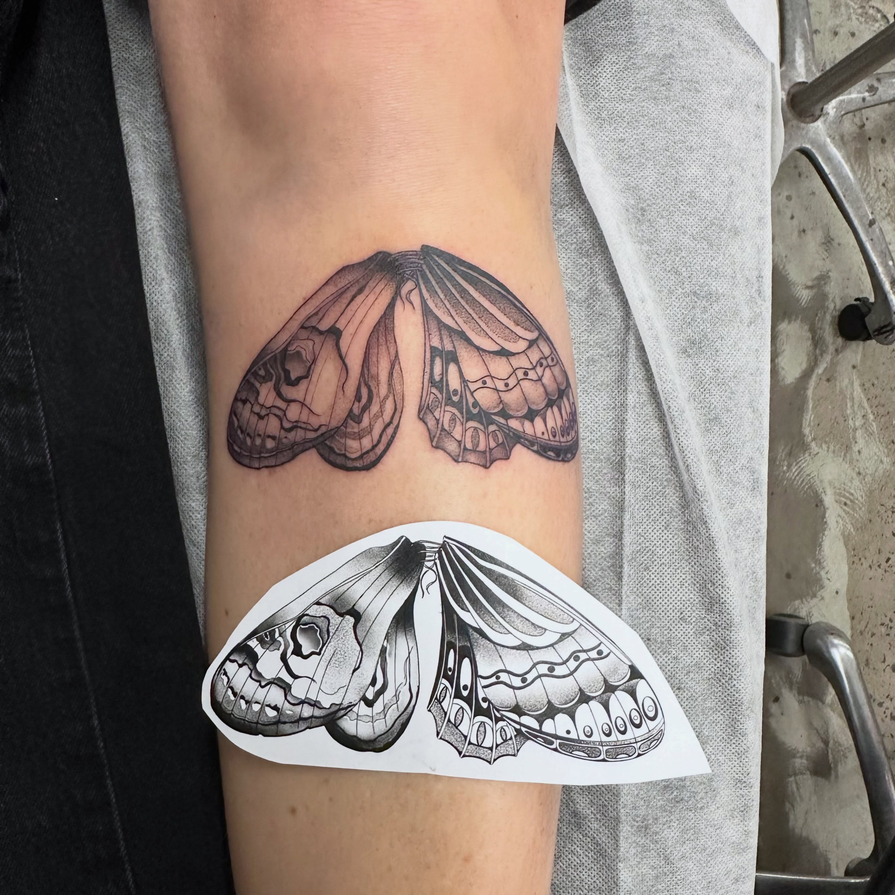 Moth wings black and grey tattoo on the forearm by Lyndsay Southgate