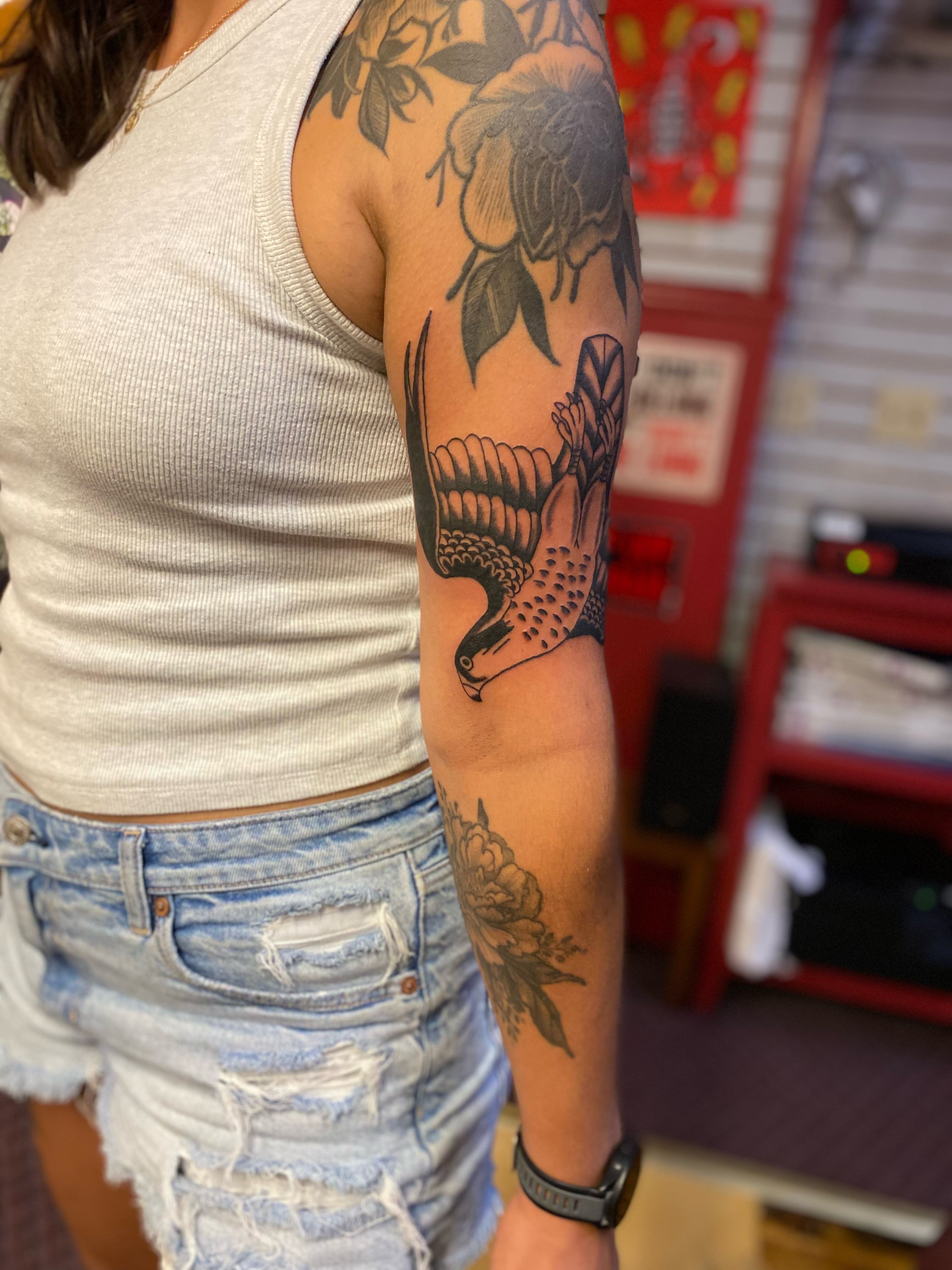 Bird and floral black and grey tattoo on the forearm by Tommy O'Connell