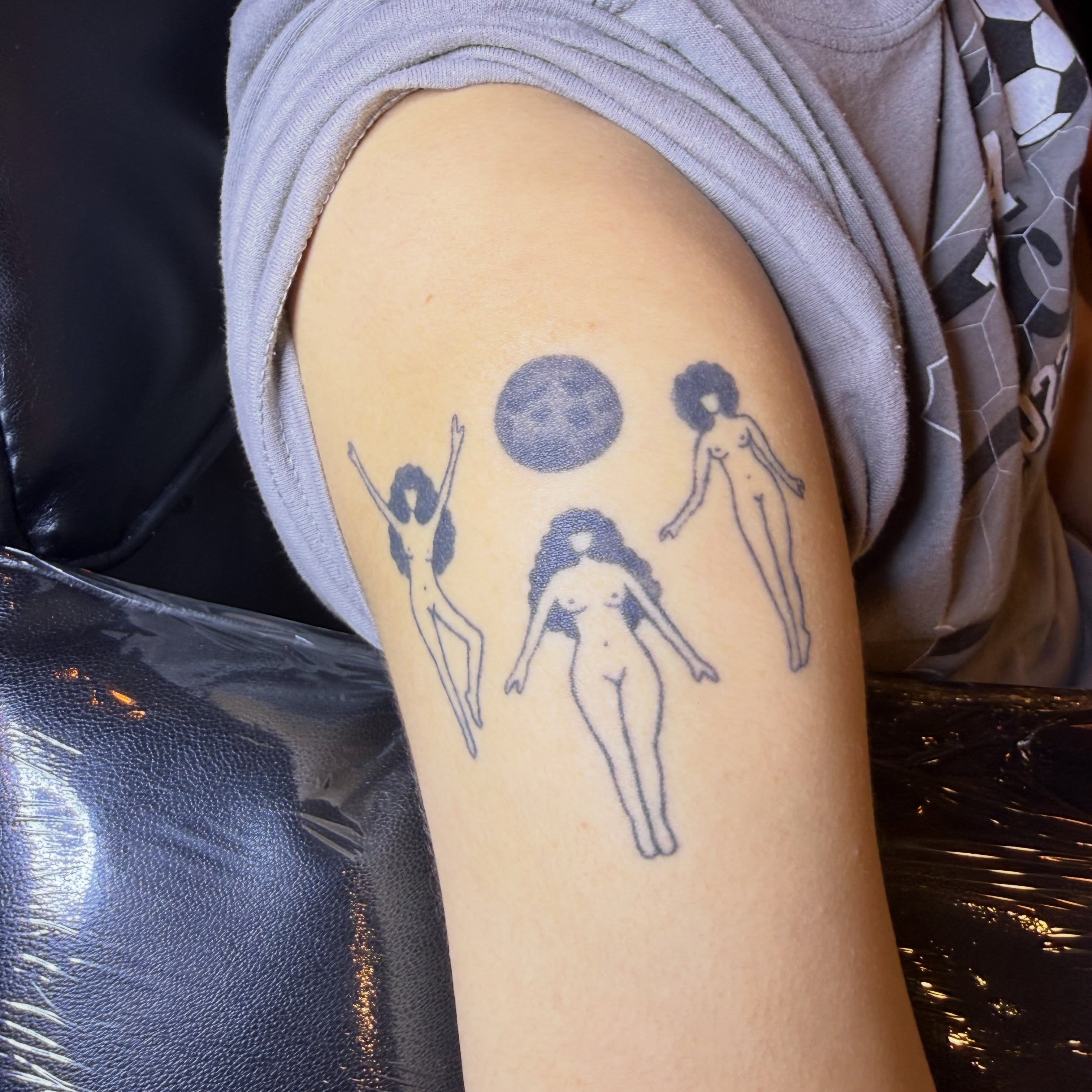 Three women and moon black and grey tattoo on the forearm by Kieara West