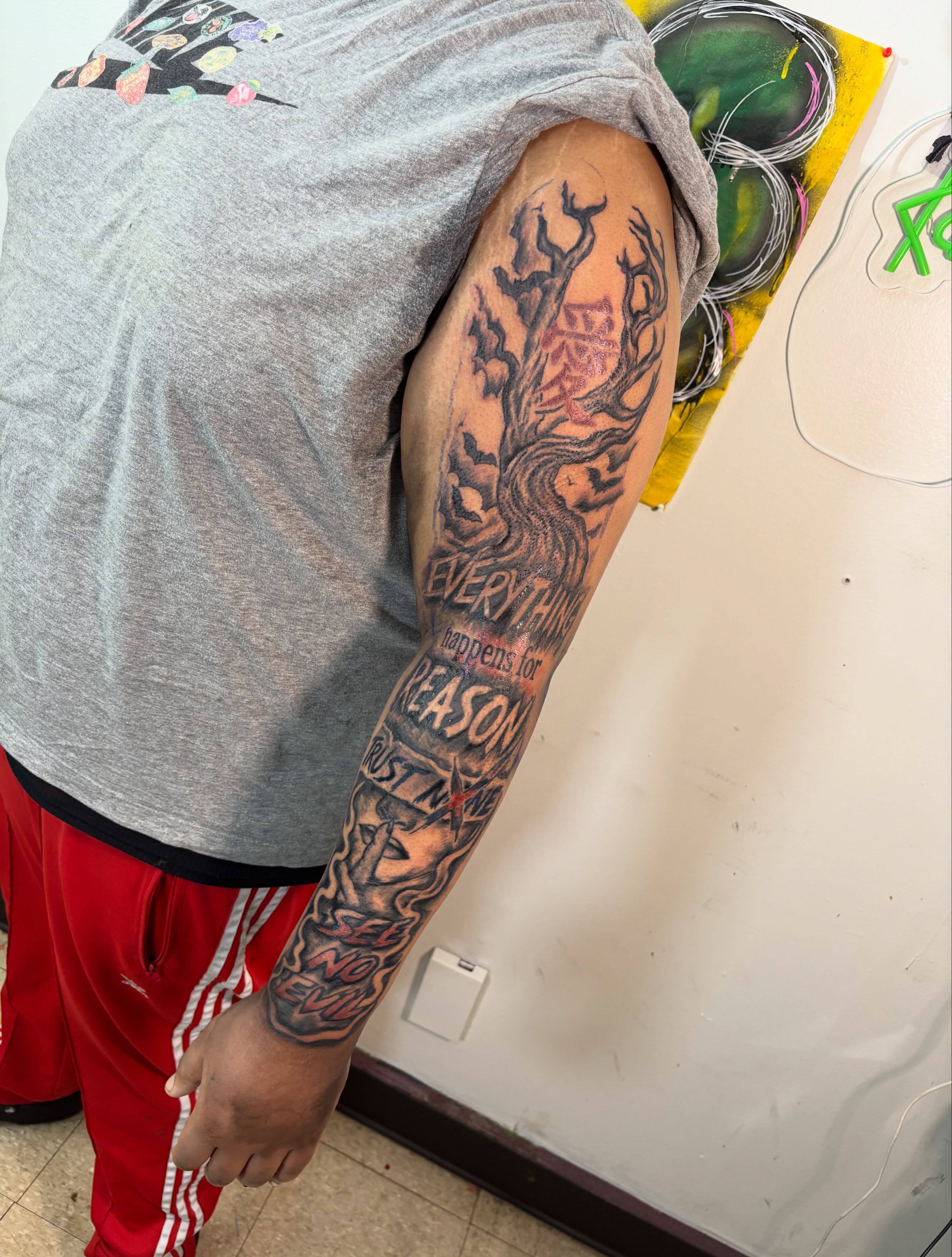 Tree with text black and grey tattoo on the upper arm by Exotic Motion🌪️