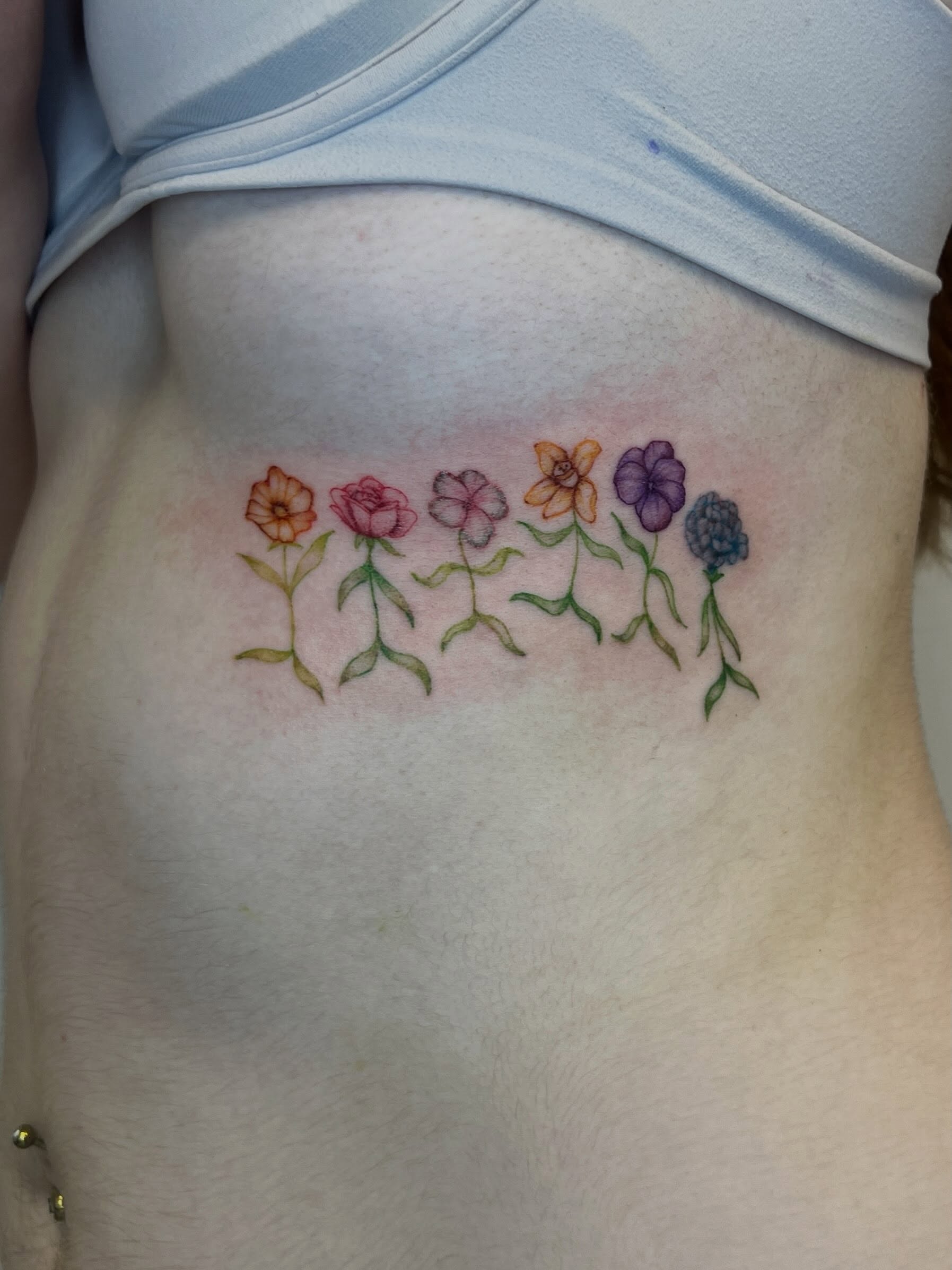 Flower row watercolor tattoo on the ribs by Presley Tattoos, Murfreesboro, Tennessee