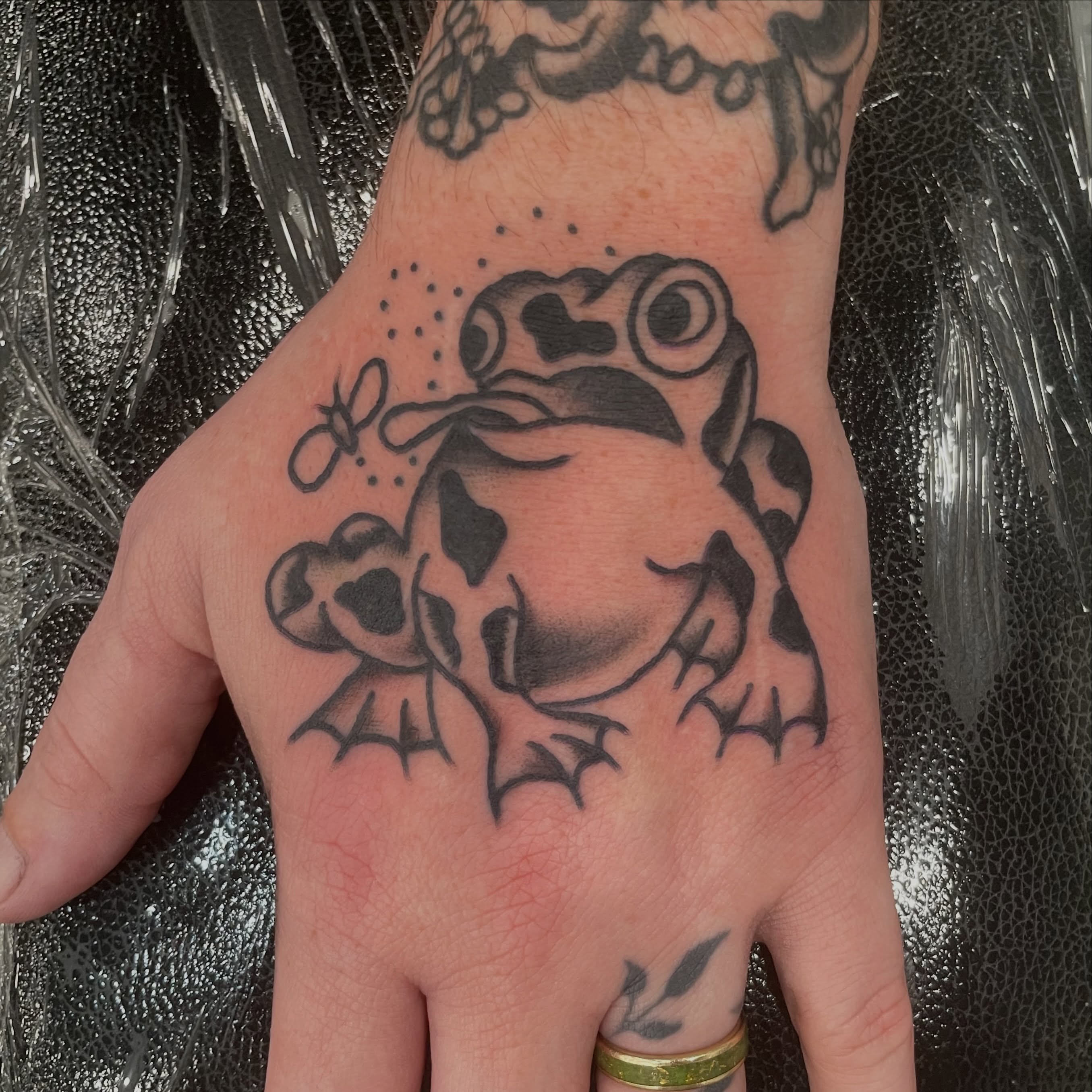 Frog American traditional tattoo on the hand by Greg De Hoot, Youngsville, North Carolina