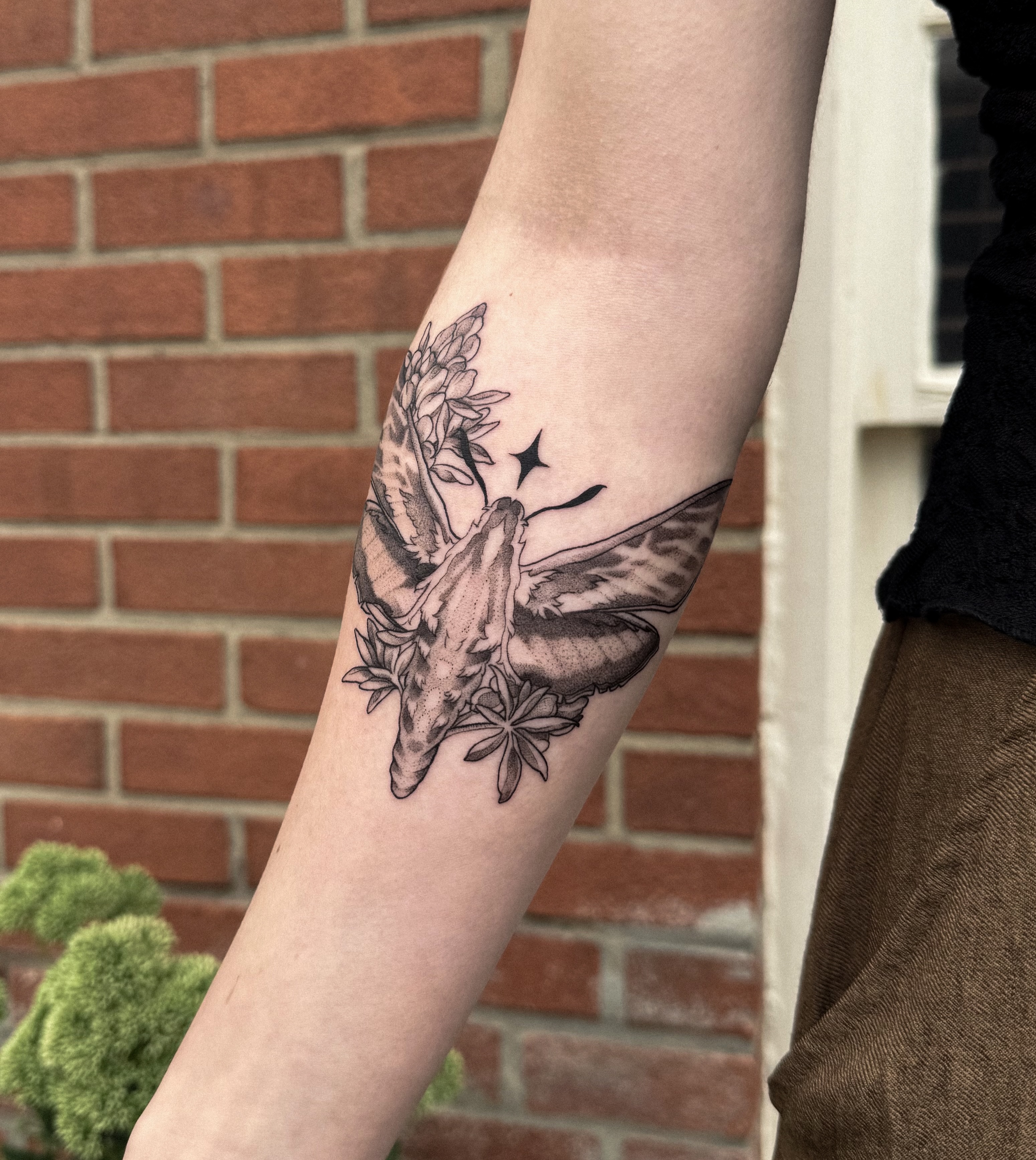 Butterfly and flowers black and grey tattoo on the forearm by Jessica Bloom