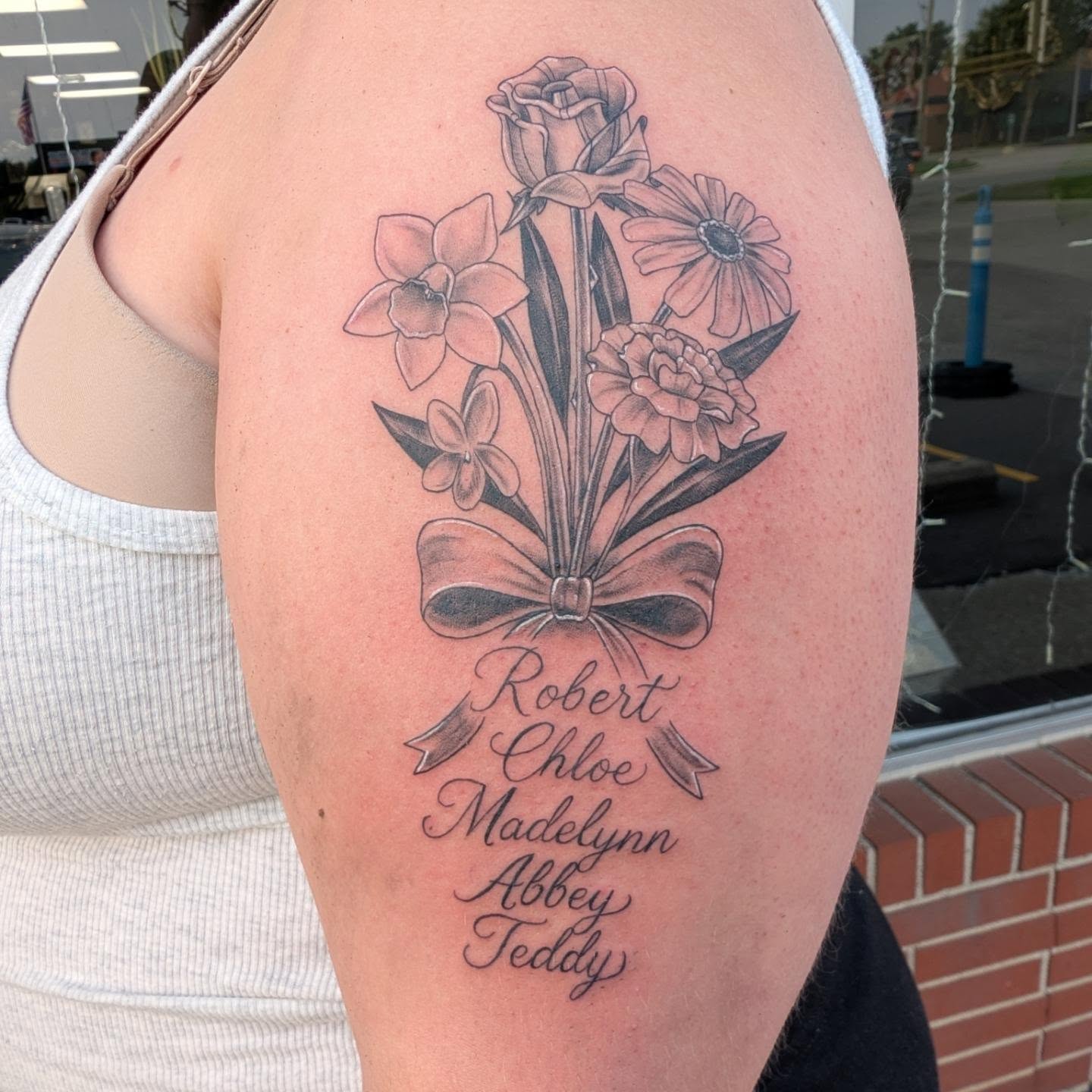 Flower bouquet black and grey tattoo on the upper arm by Hannah Hayes, Livonia, Michigan