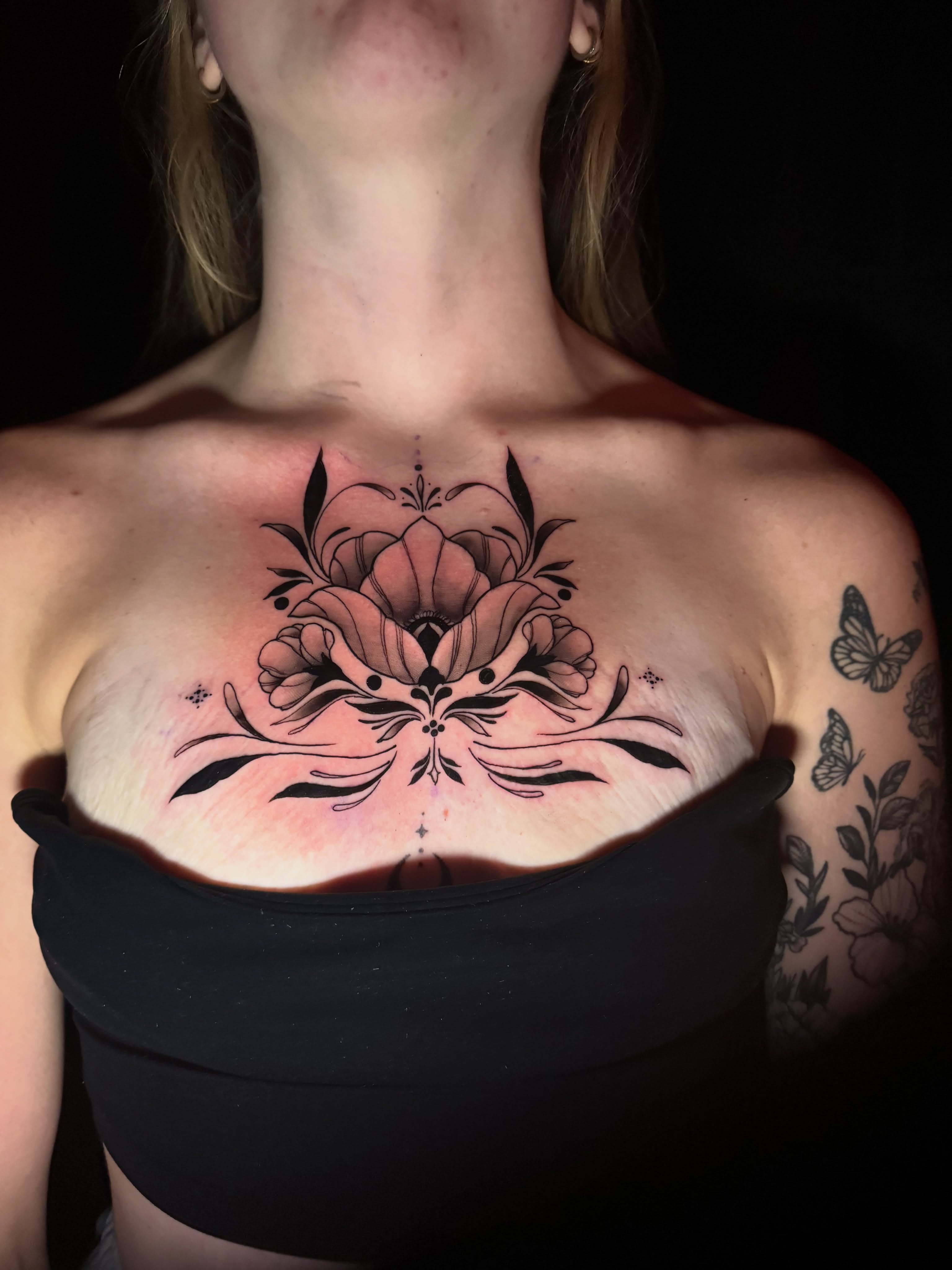 Floral bouquet black and grey tattoo on the chest by tori 🫶🏻