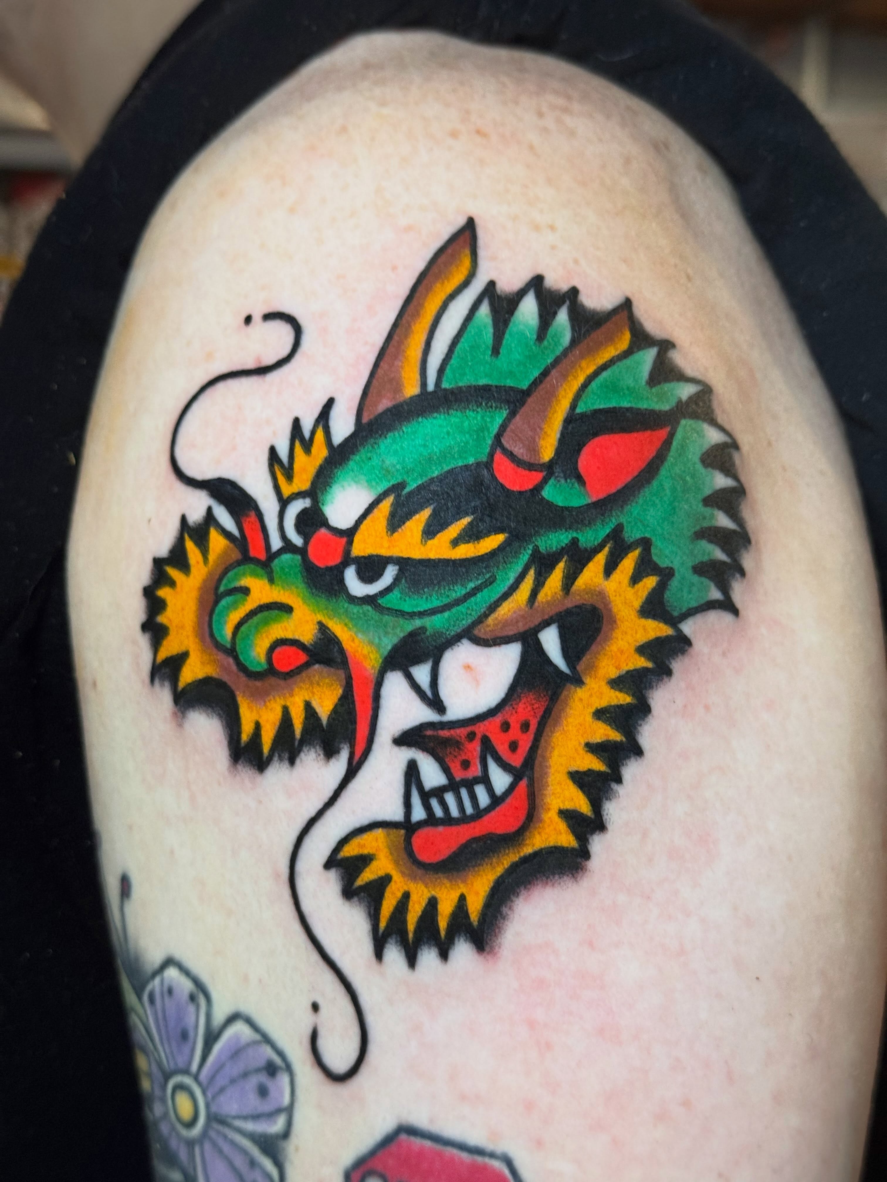 Dragon head American traditional tattoo on the shoulder by Zach Lemieux