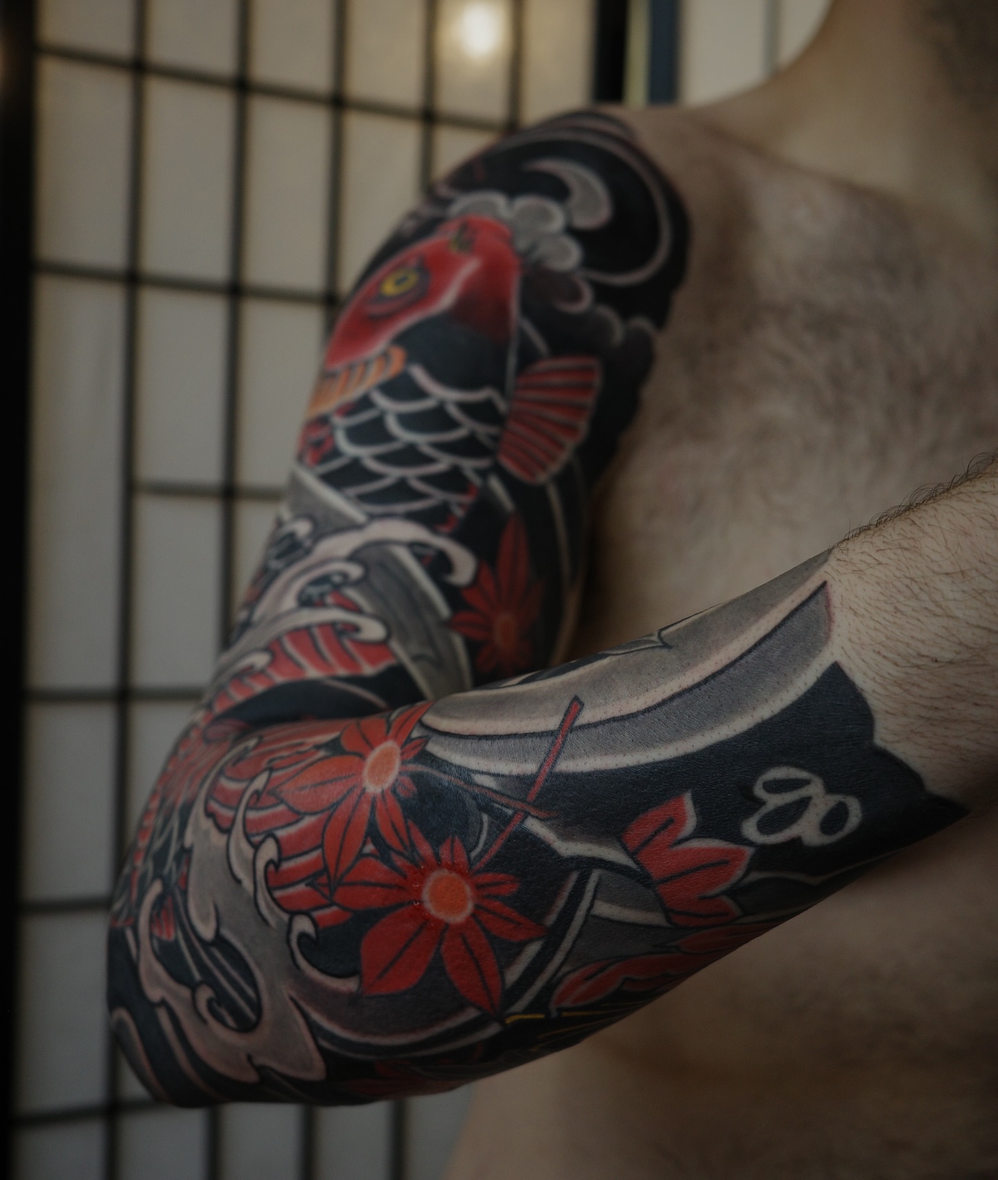 Koi fish and flowers japanese irezumi tattoo on the upper arm by Innokenty Meshchakov, Portland, Oregon