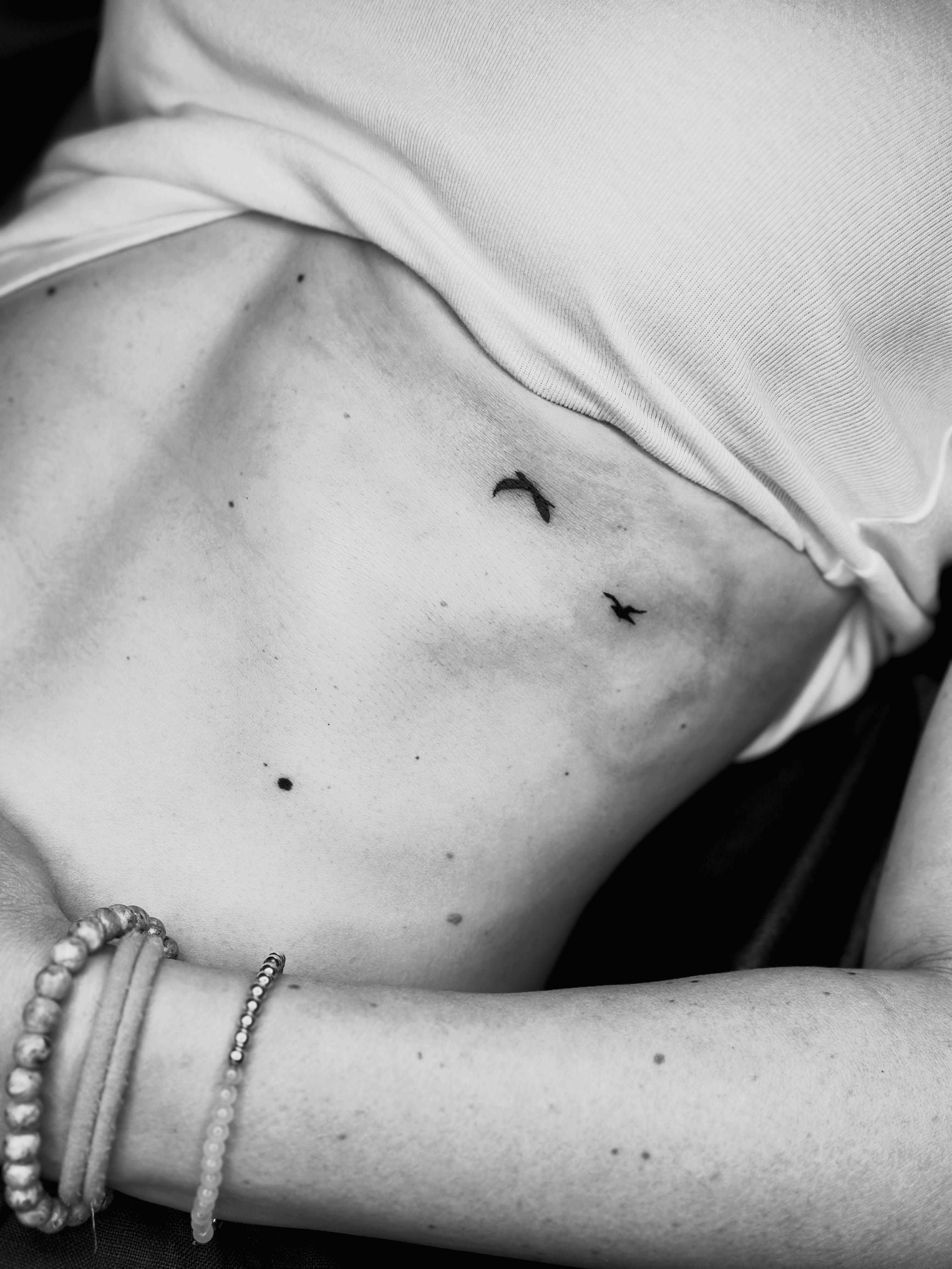 Birds black and grey tattoo on the torso by Liz