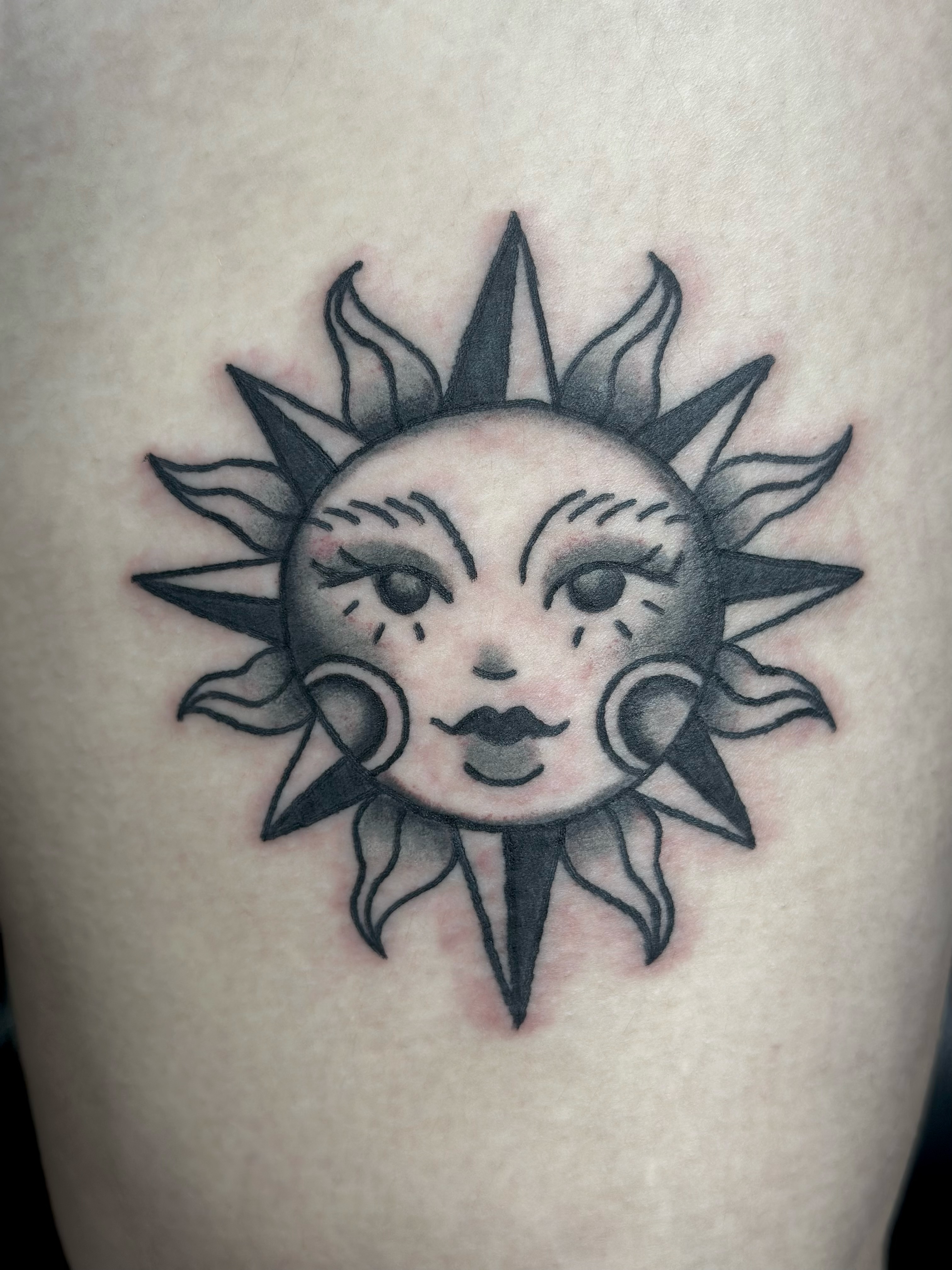 Sun American traditional tattoo on the thigh by Lucy Jay