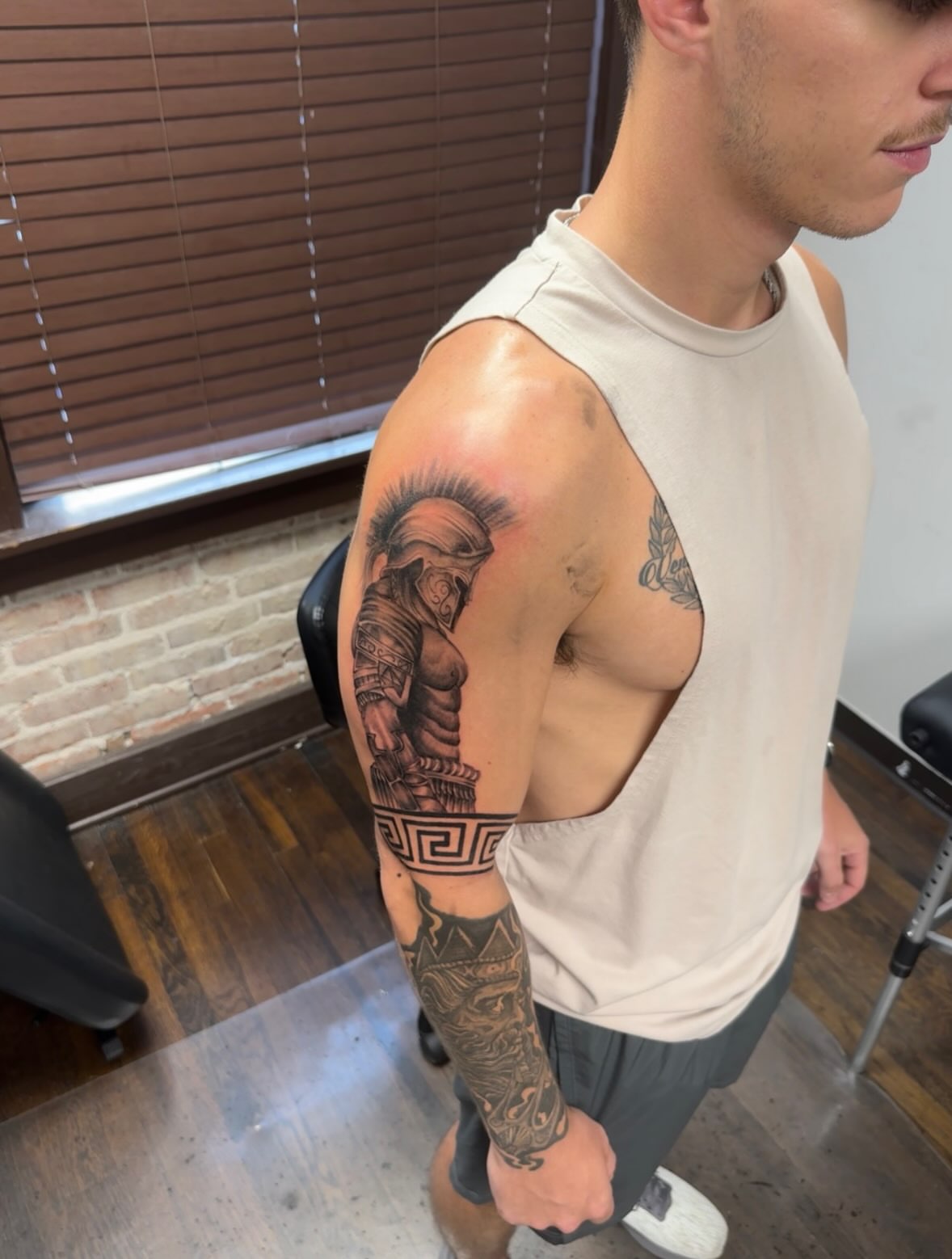 Spartan warrior helmet black and grey tattoo on the upper arm by Willi Tattoos👹