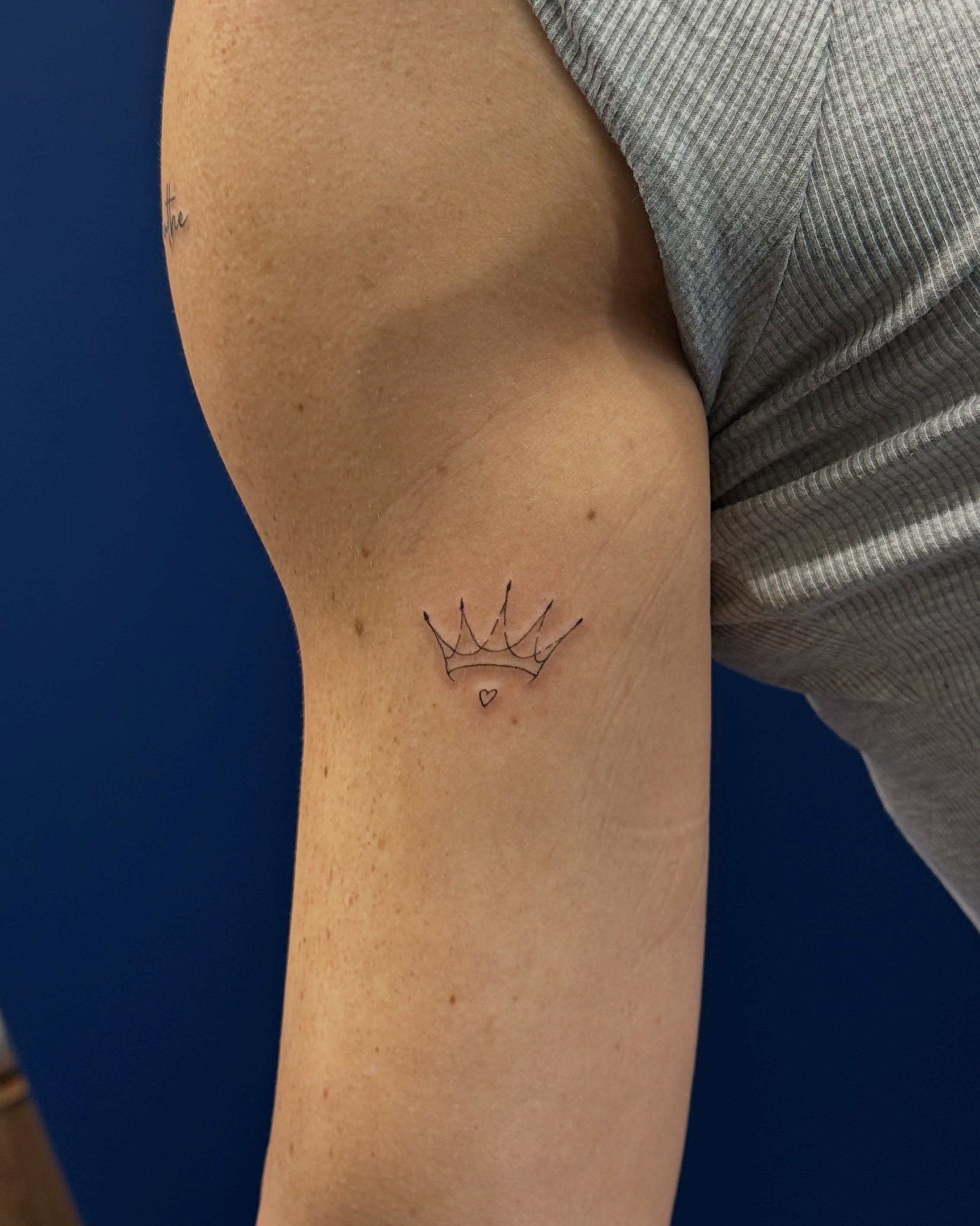 Crown fine line tattoo on the forearm by Tattoo Takayo