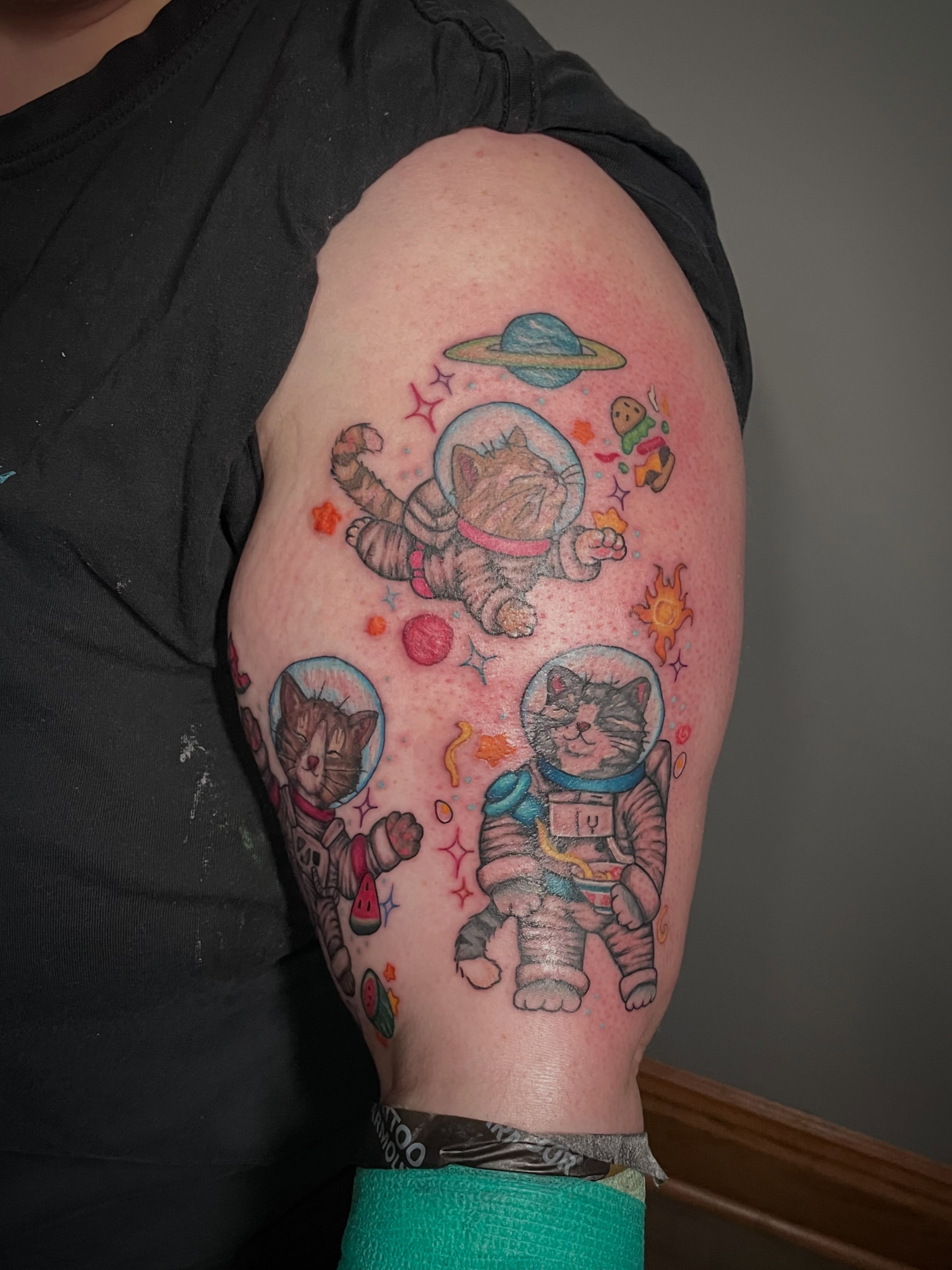 Astronaut cats new school tattoo on the upper arm by Hannah Copeskey