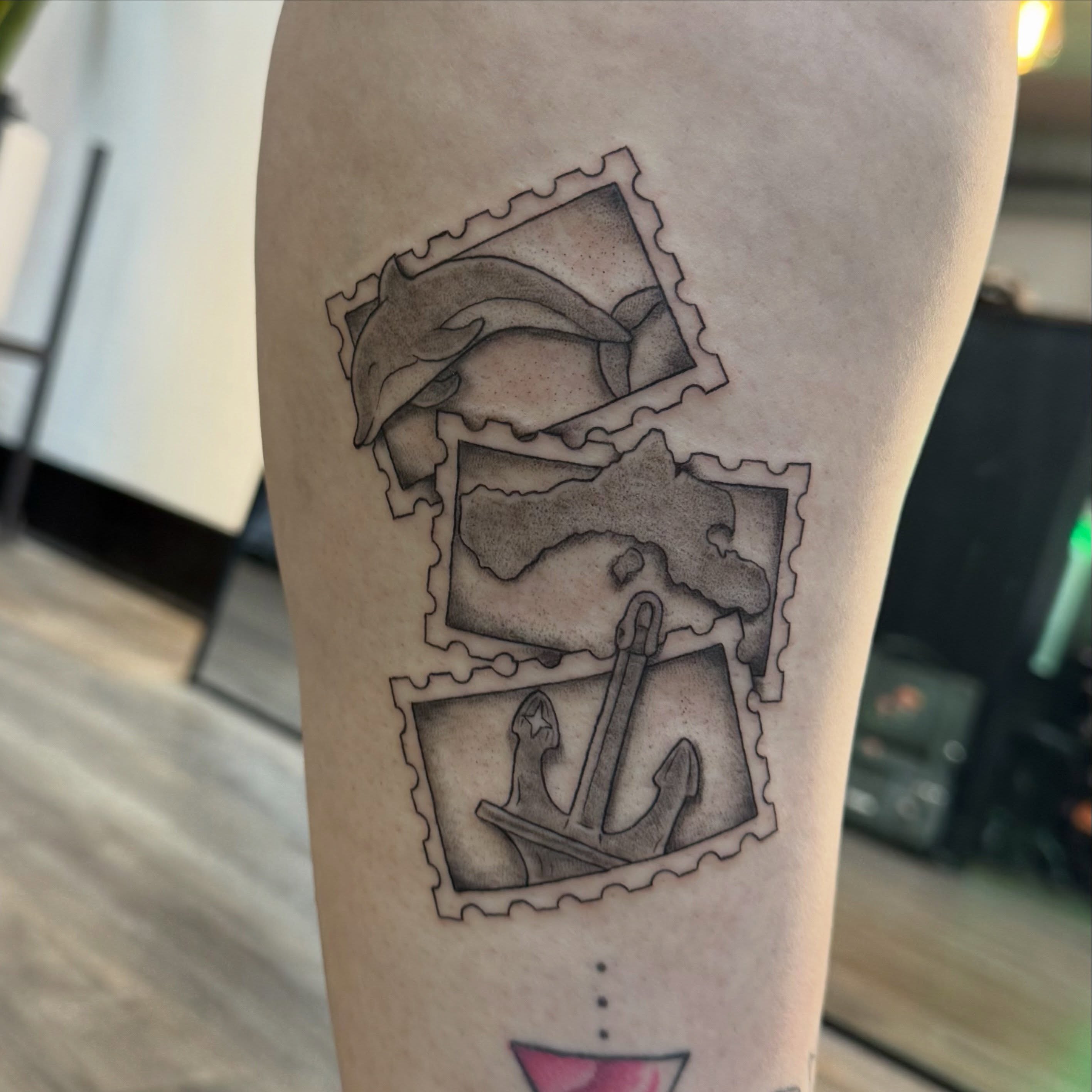 Postage stamps black and grey tattoo on the forearm by Kate Marie