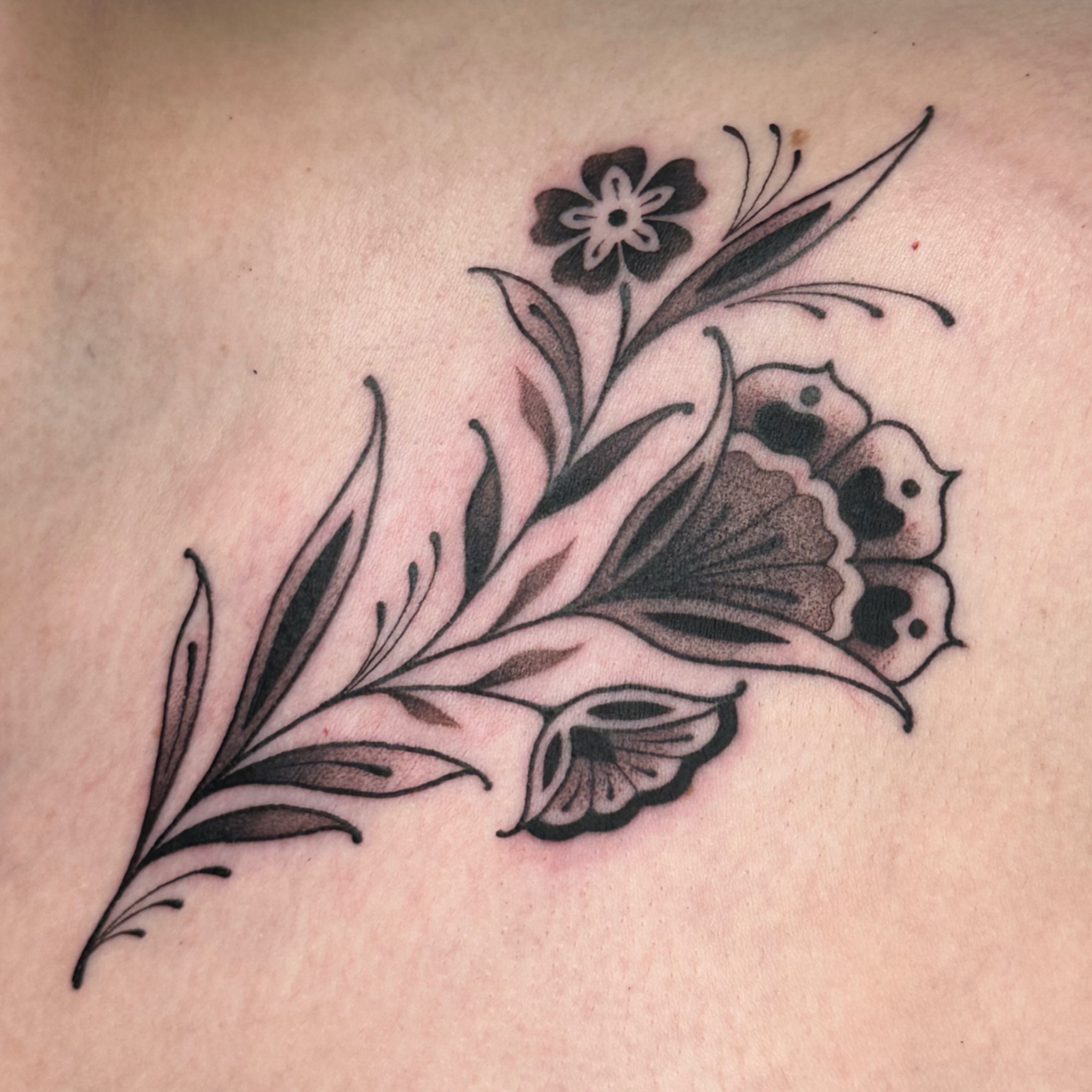 Flower bouquet black and grey tattoo on the back by kira
