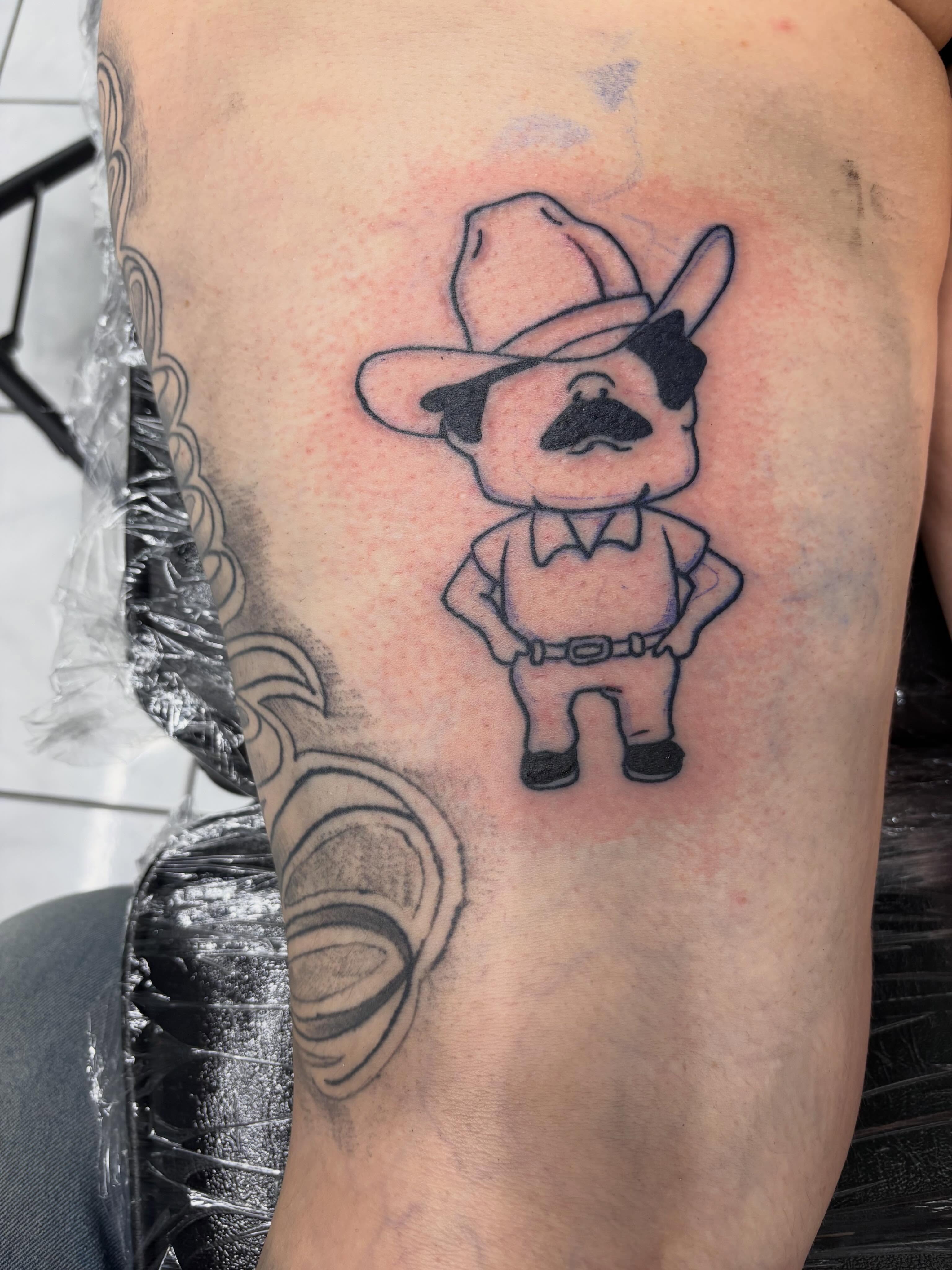 Cowboy character black and grey tattoo on the forearm by Shadows Tattoos