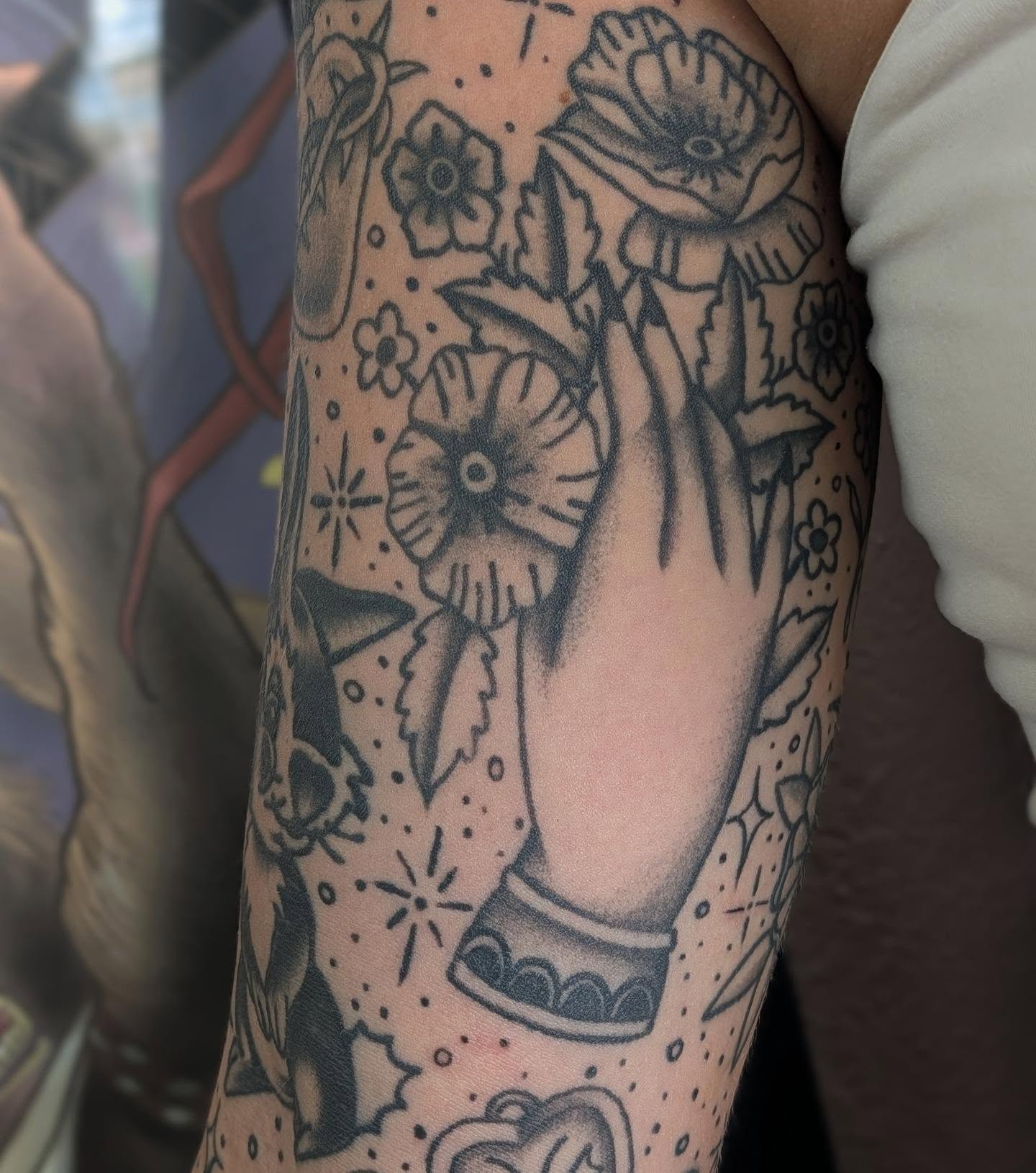 Hand with flowers American traditional tattoo on the forearm by Alexandria Green