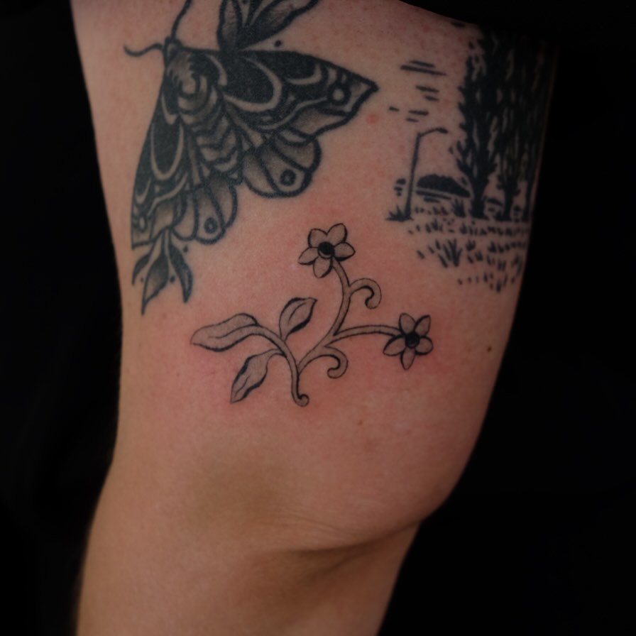 Butterfly and flowers black and grey tattoo on the forearm by lela