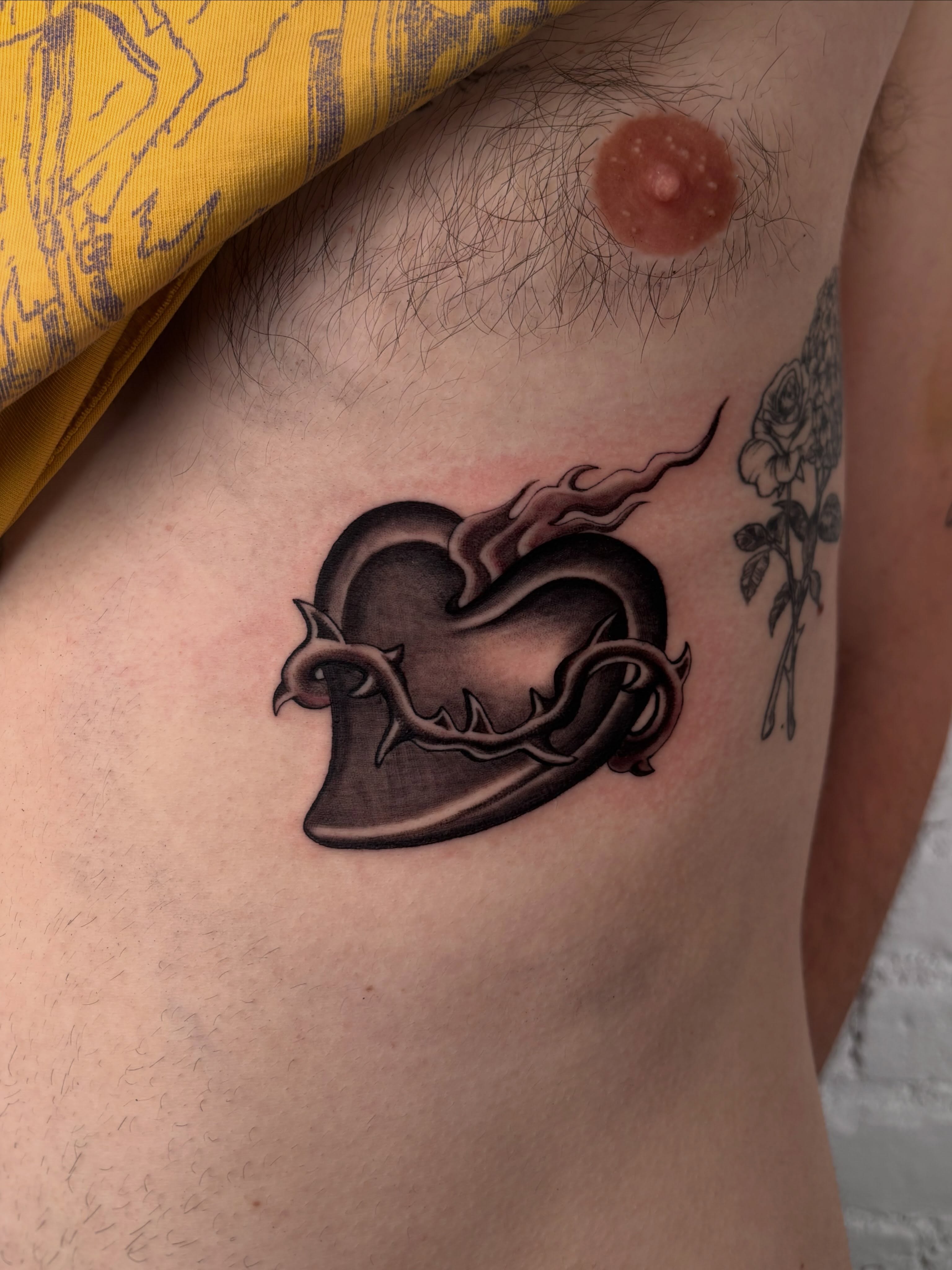 Heart with thorns black and grey tattoo on the ribs by laura bianca