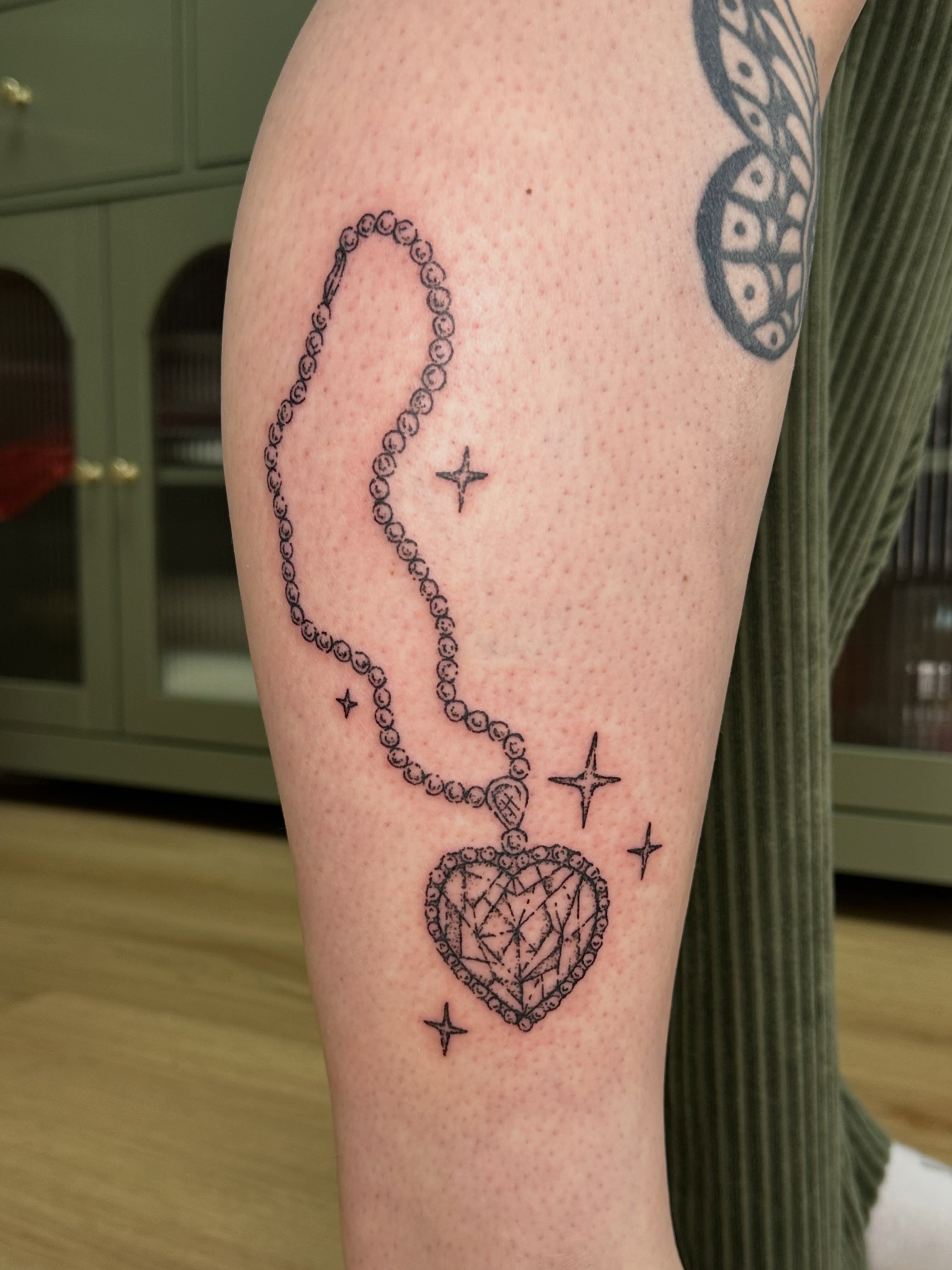 Necklace and heart black and grey tattoo on the forearm by Fleur ๐ฅ