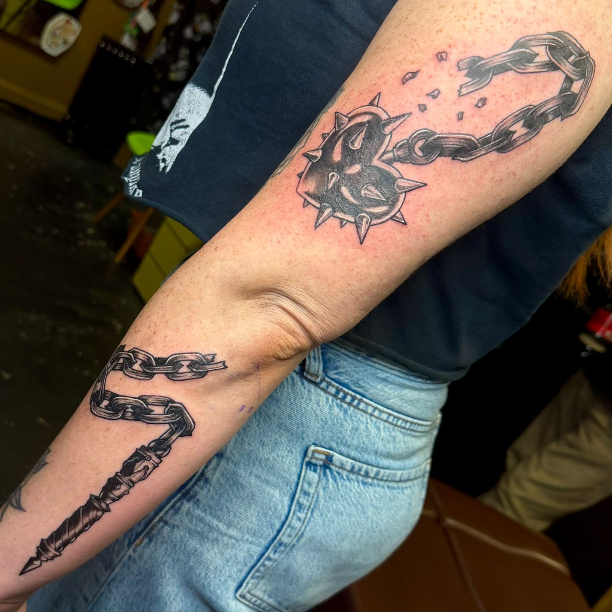 Spiked collar and chain black and grey tattoo on the forearm by Kenneth Prince